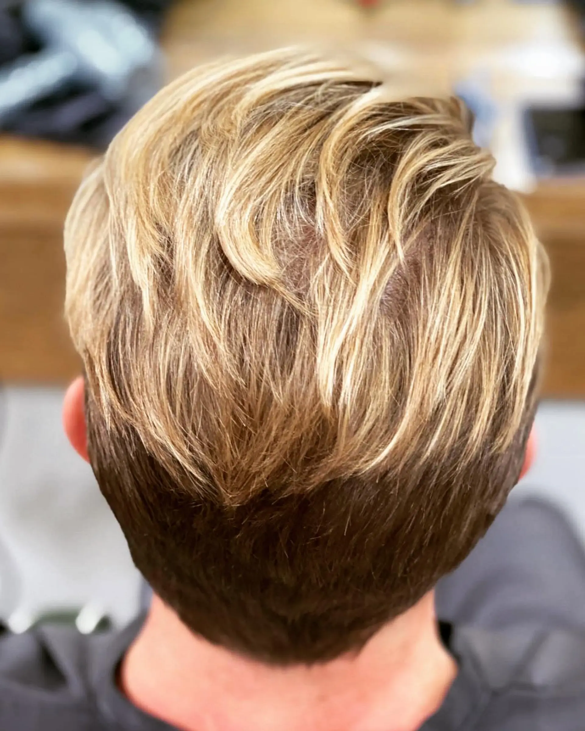 A men's short textured cut featuring sun-kissed golden blonde balayage layered over a light brown base. 1