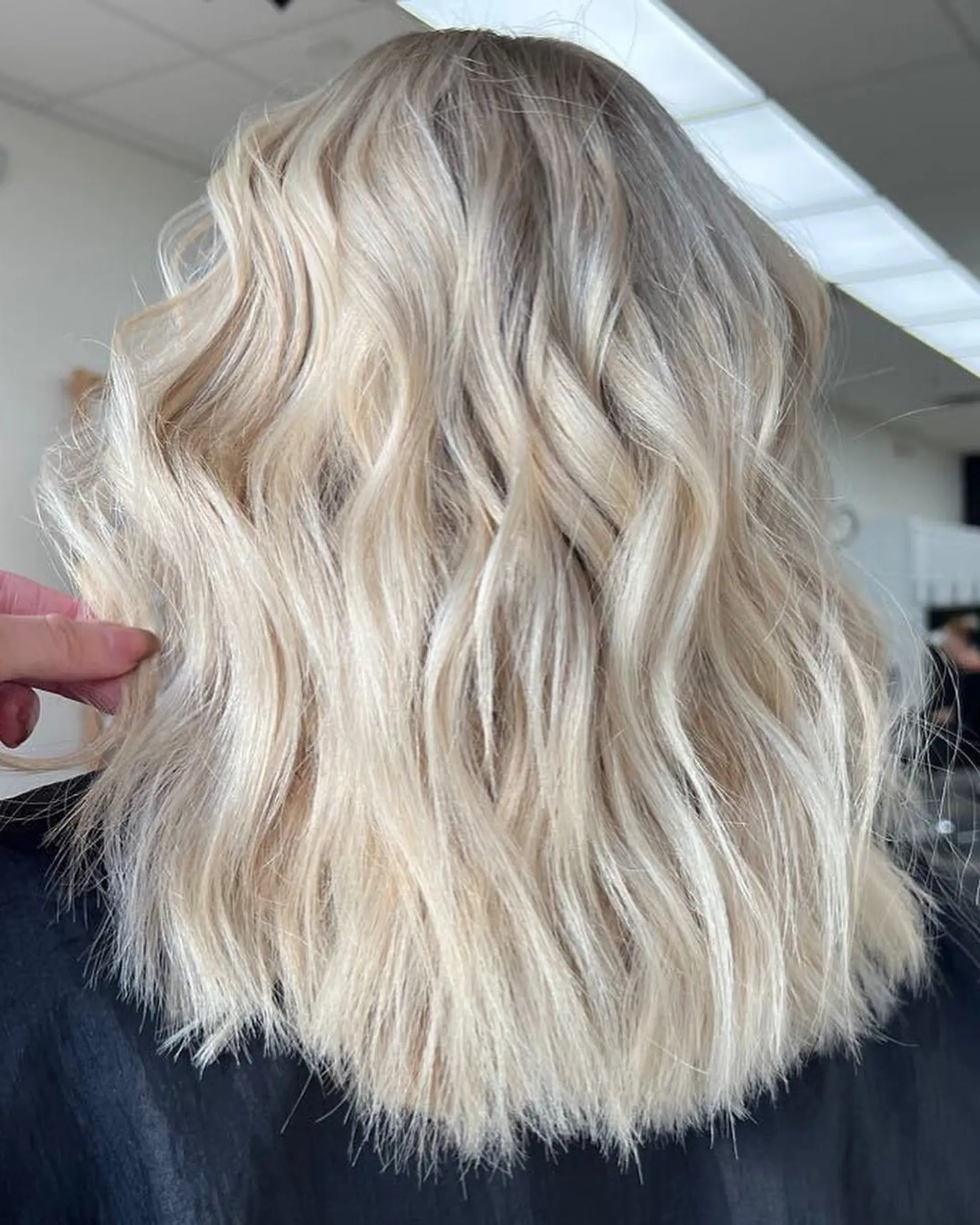 Medium-length bright platinum blonde lob styled with soft, piecey, beachy waves. 1