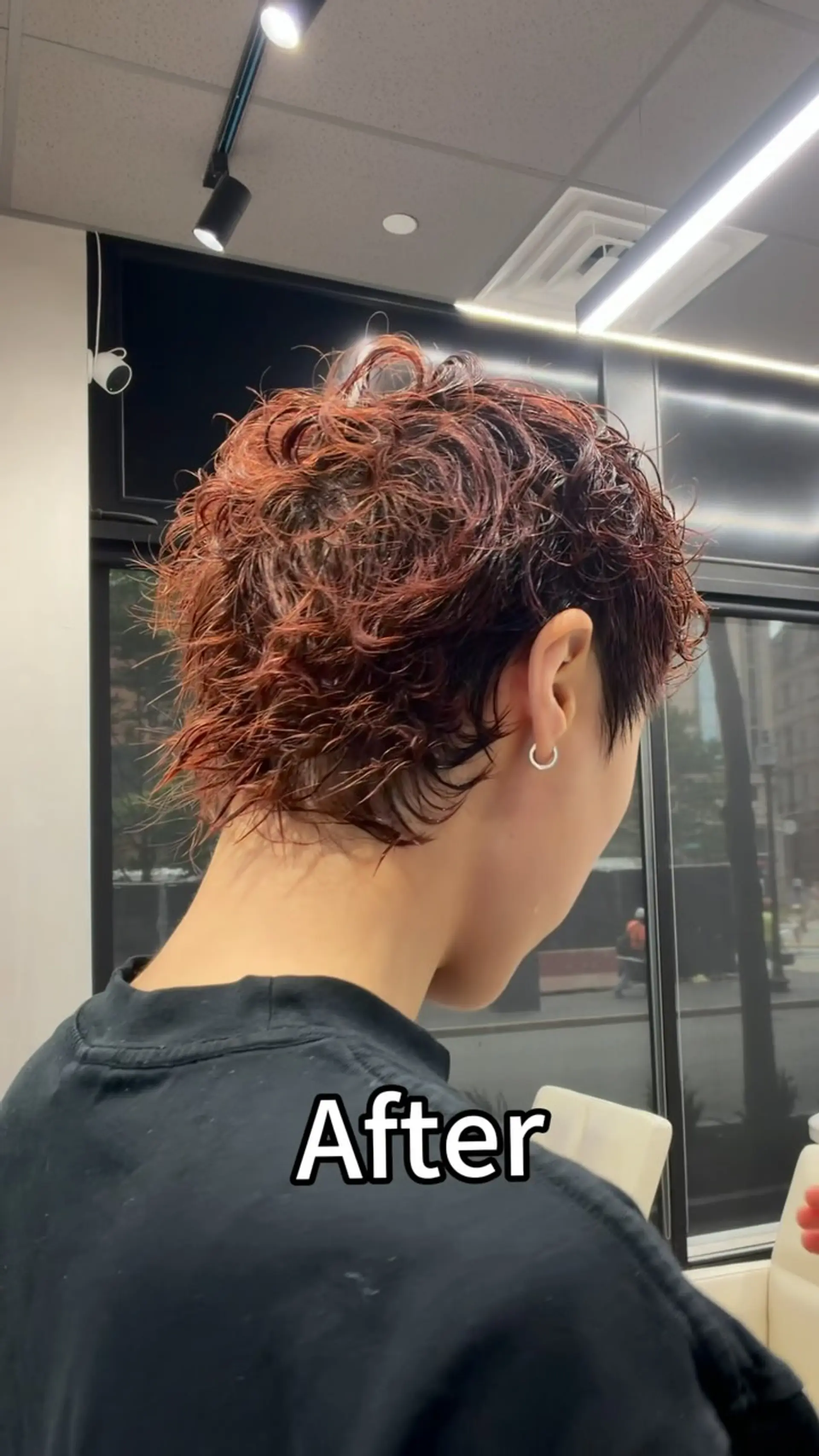A textured short haircut enhanced with a defined wavy perm in a warm reddish-brown tone. 1