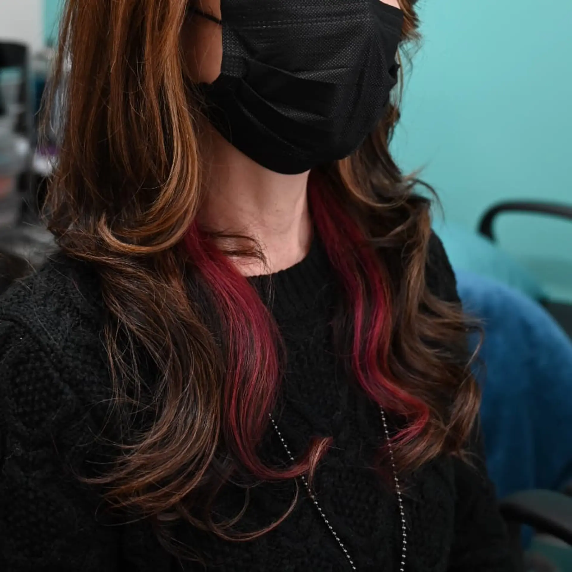 Medium-length layered brunette hair with subtle caramel highlights and vivid magenta peek-a-boo underlights. 1