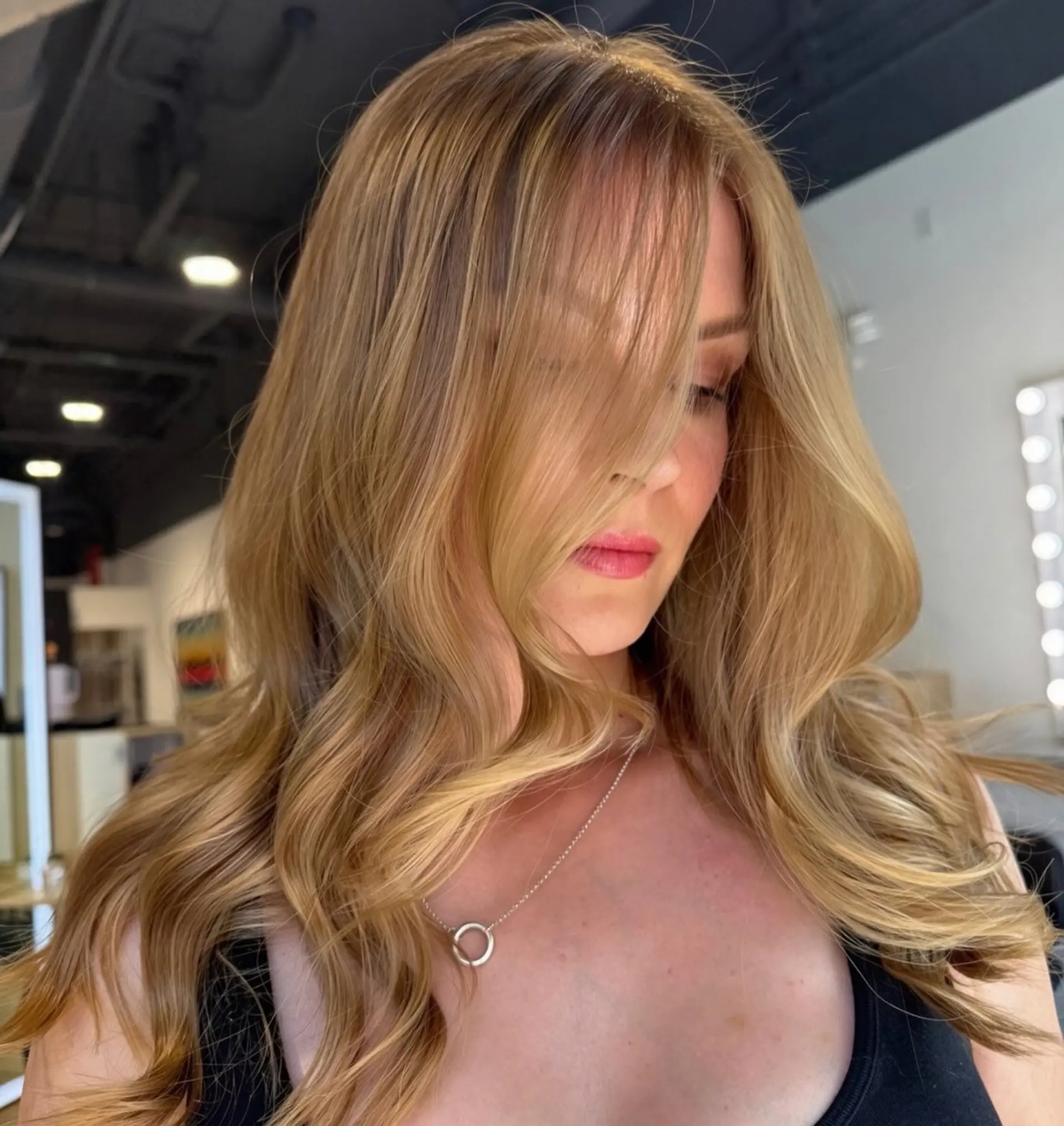Long strawberry blonde hair cut with flowing face-framing layers and styled in soft, voluminous waves. 1