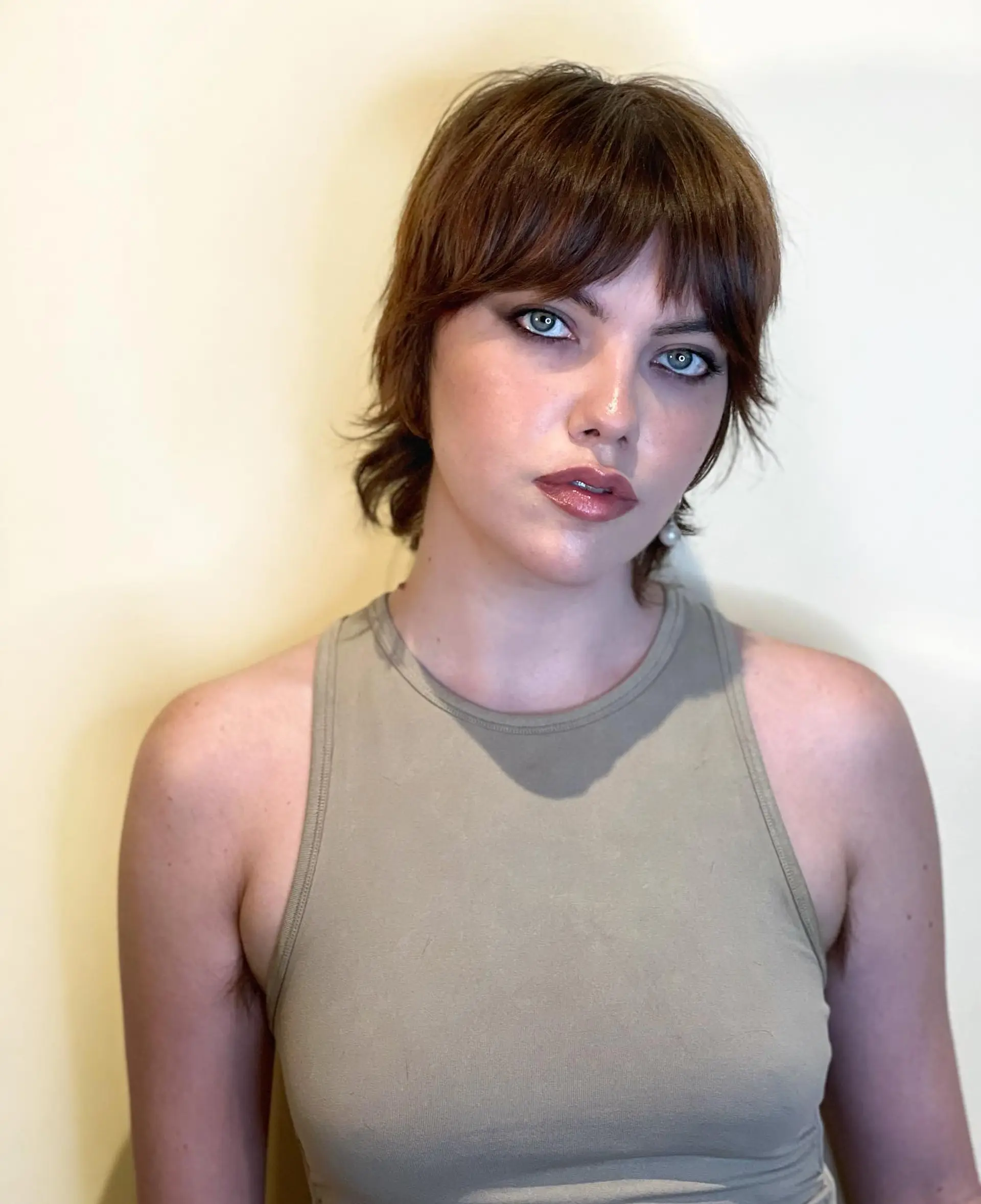 A layered, medium-length shag haircut with textured bangs. 1