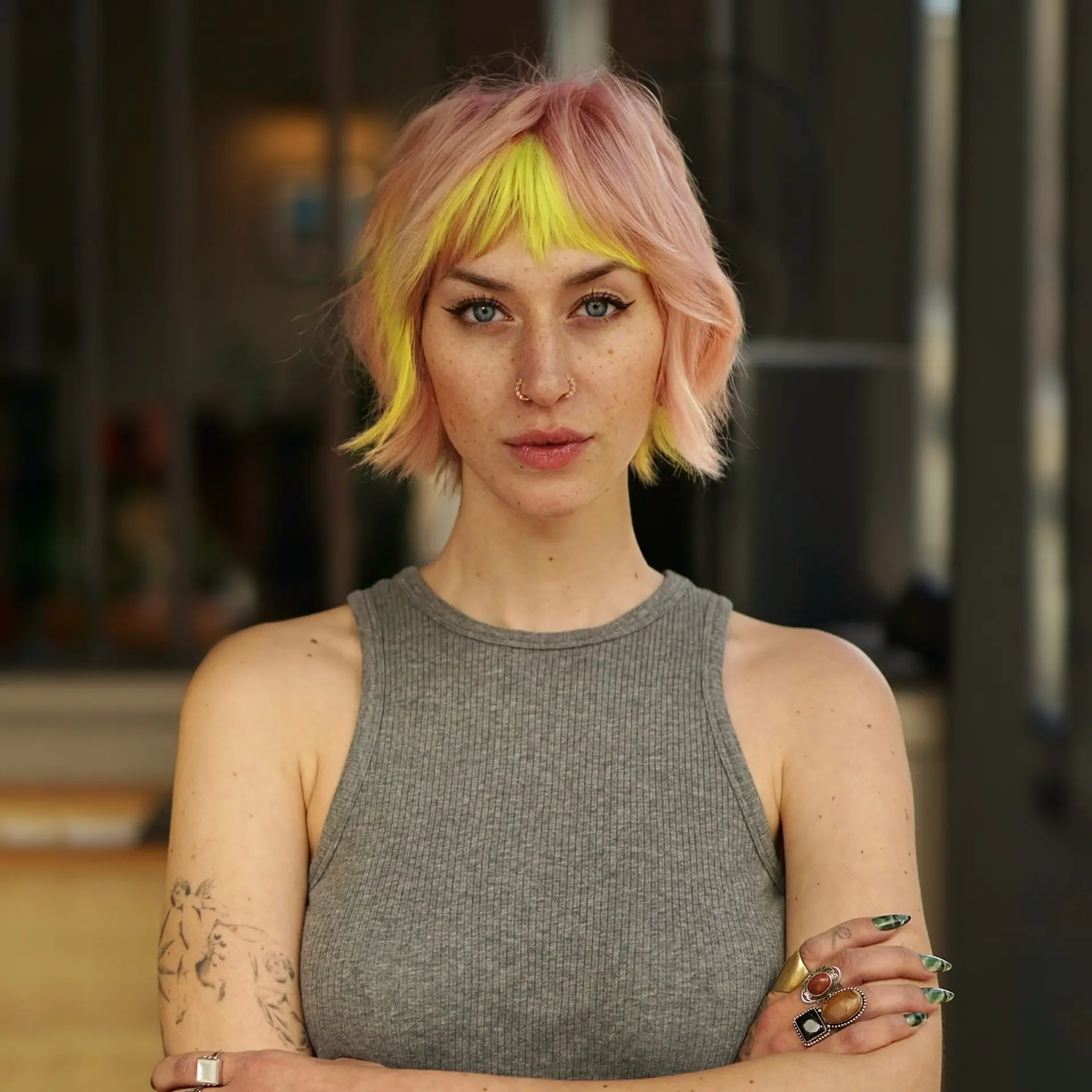 A textured short bixie cut with pastel pink lengths and bold neon yellow bangs. 1
