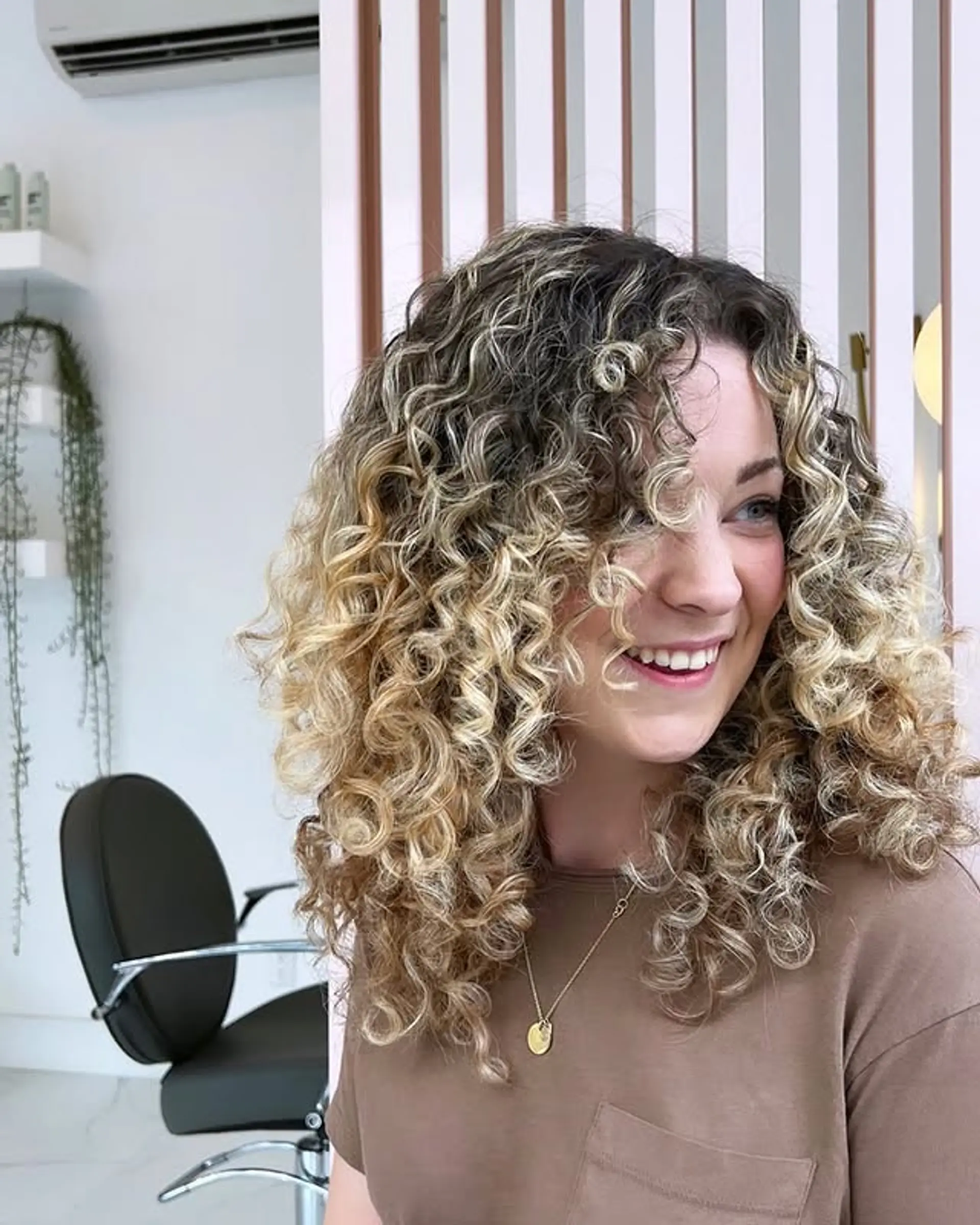 This hairstyle features voluminous natural curls in a shoulder-length lob, with layered ends. 1