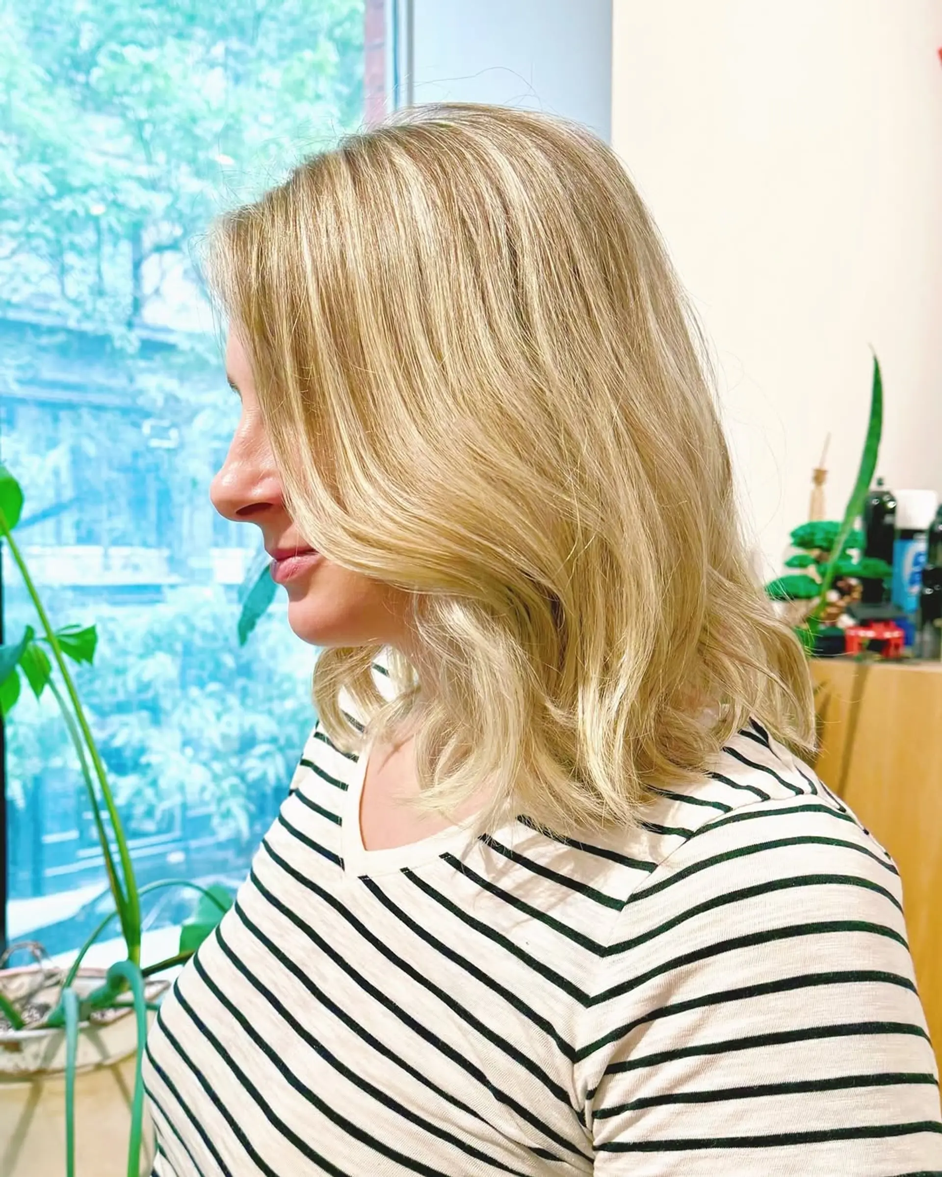 This hairstyle features medium length blonde hair styled in soft, beachy waves with subtle layers. 2