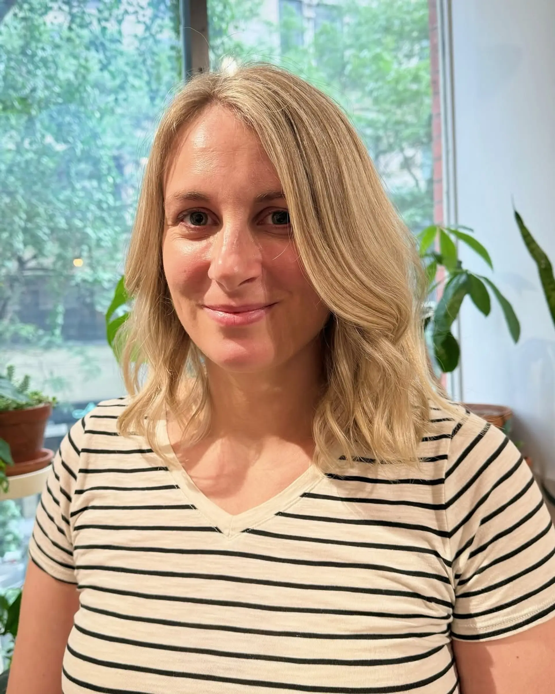 This hairstyle features medium length blonde hair styled in soft, beachy waves with subtle layers. 3