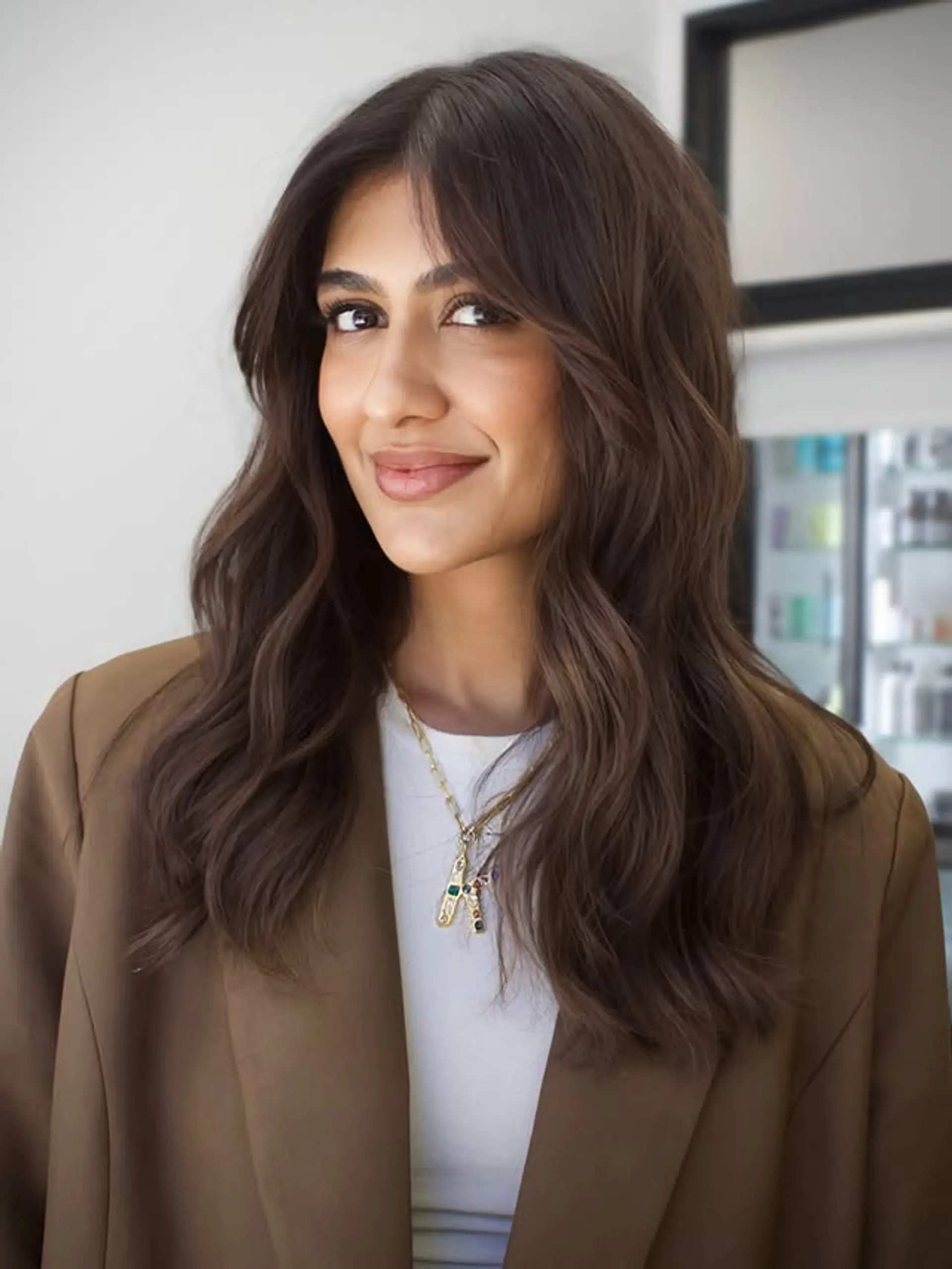 A medium-length wavy hairstyle with face-framing layers. 1