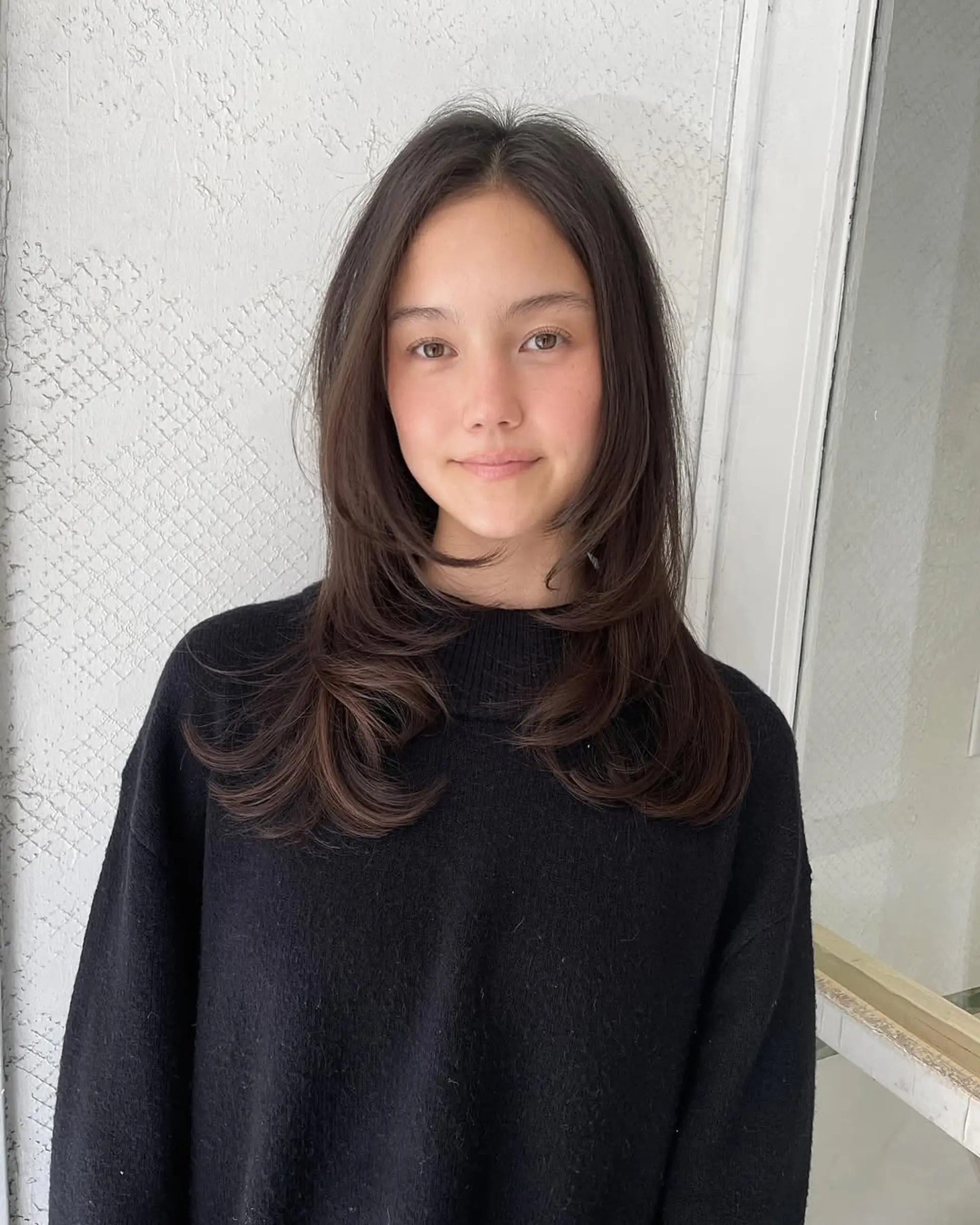 A long, straight hairstyle with layered ends and face-framing cut in dark brown color. 1