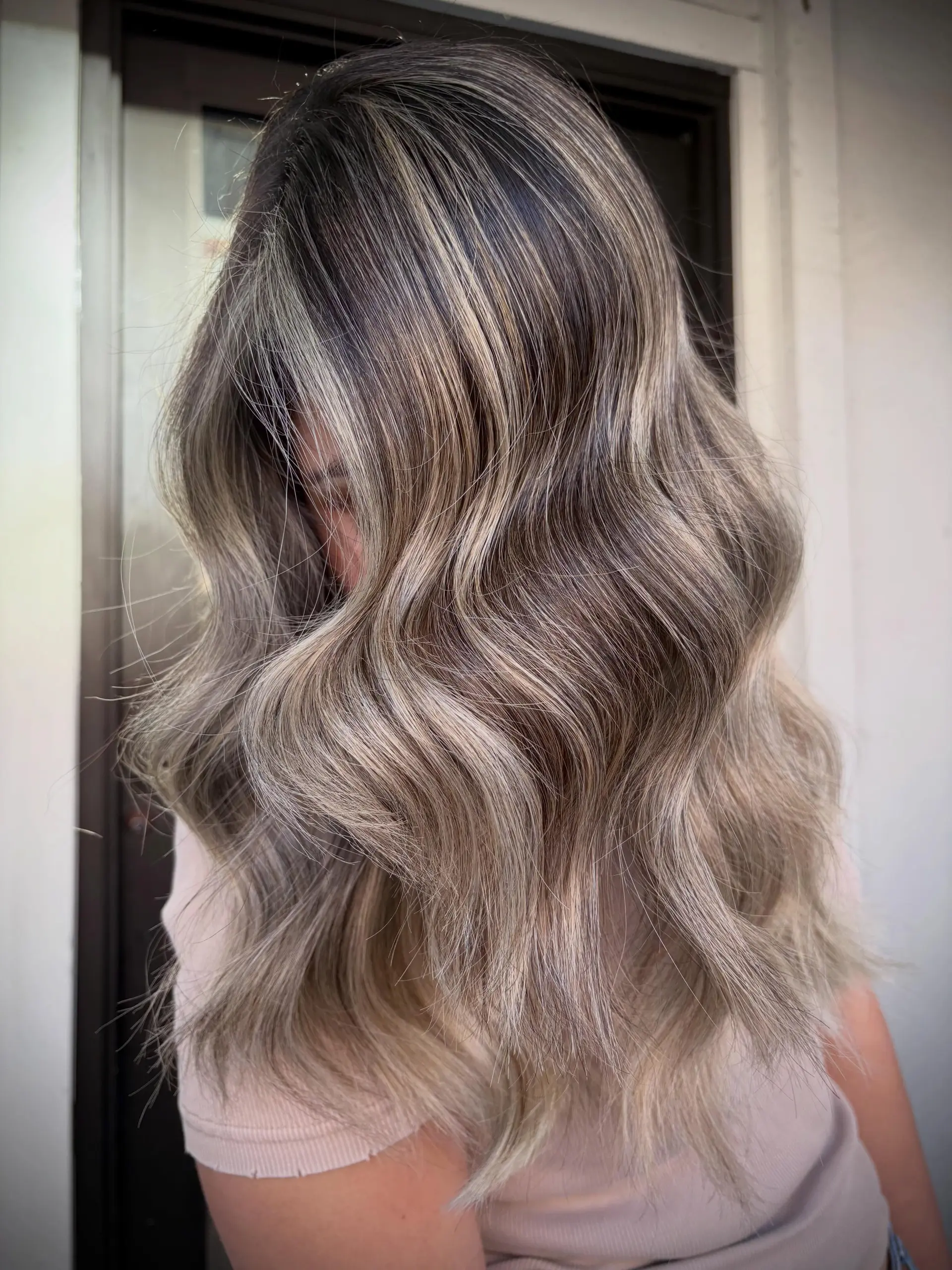 Long cool-toned ash blonde balayage styled with soft, cascading s-waves. 1