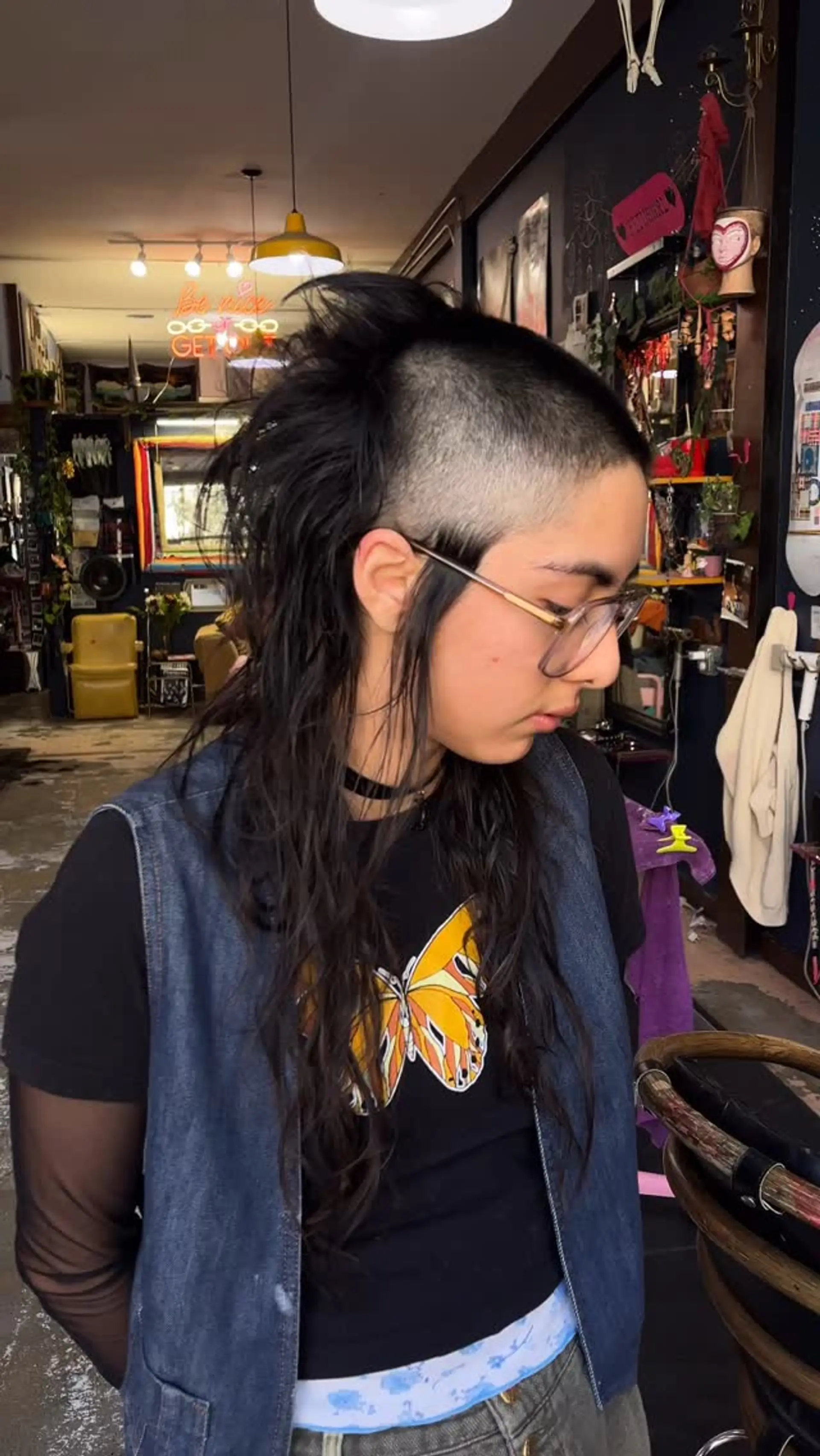 An edgy punk skullet haircut featuring closely buzzed and faded sides paired with long, textured wavy hair extending down the back. 1
