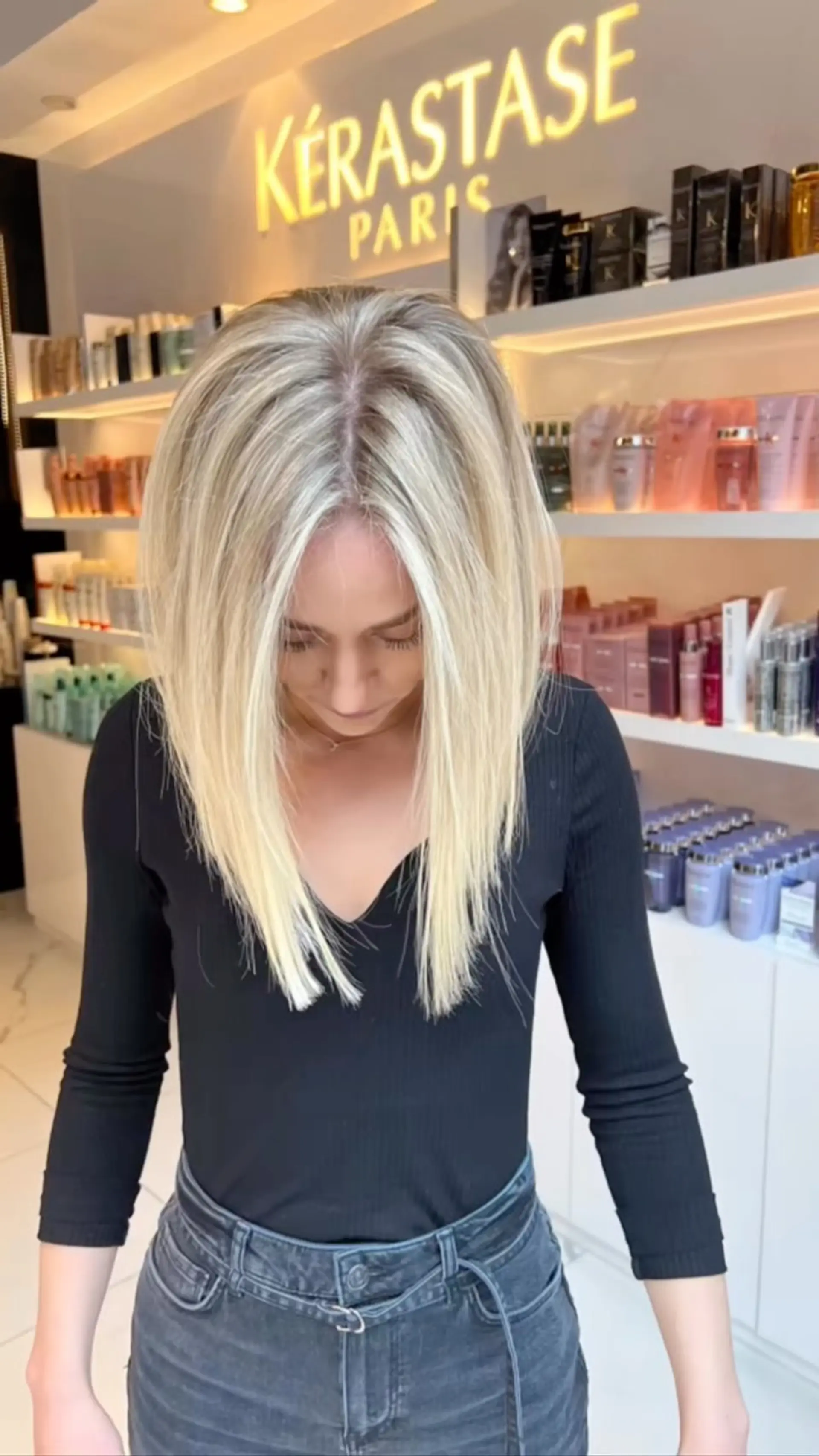 A sleek, medium-length lob styled straight with a center part and bright blonde highlights. 1
