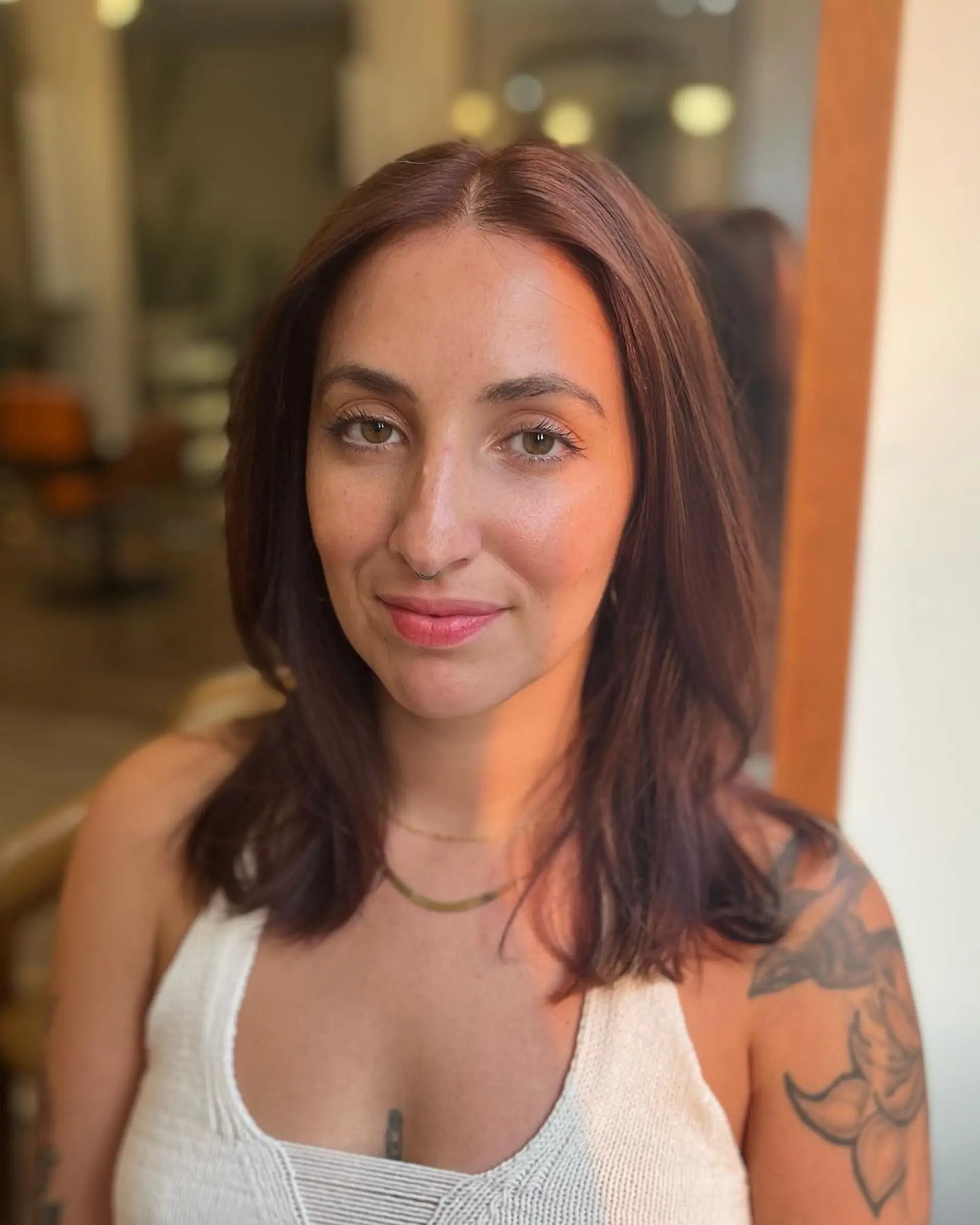 Medium-length, chestnut-colored hair styled in soft waves with a side part and subtle layers, showcasing natural shine and health. 2