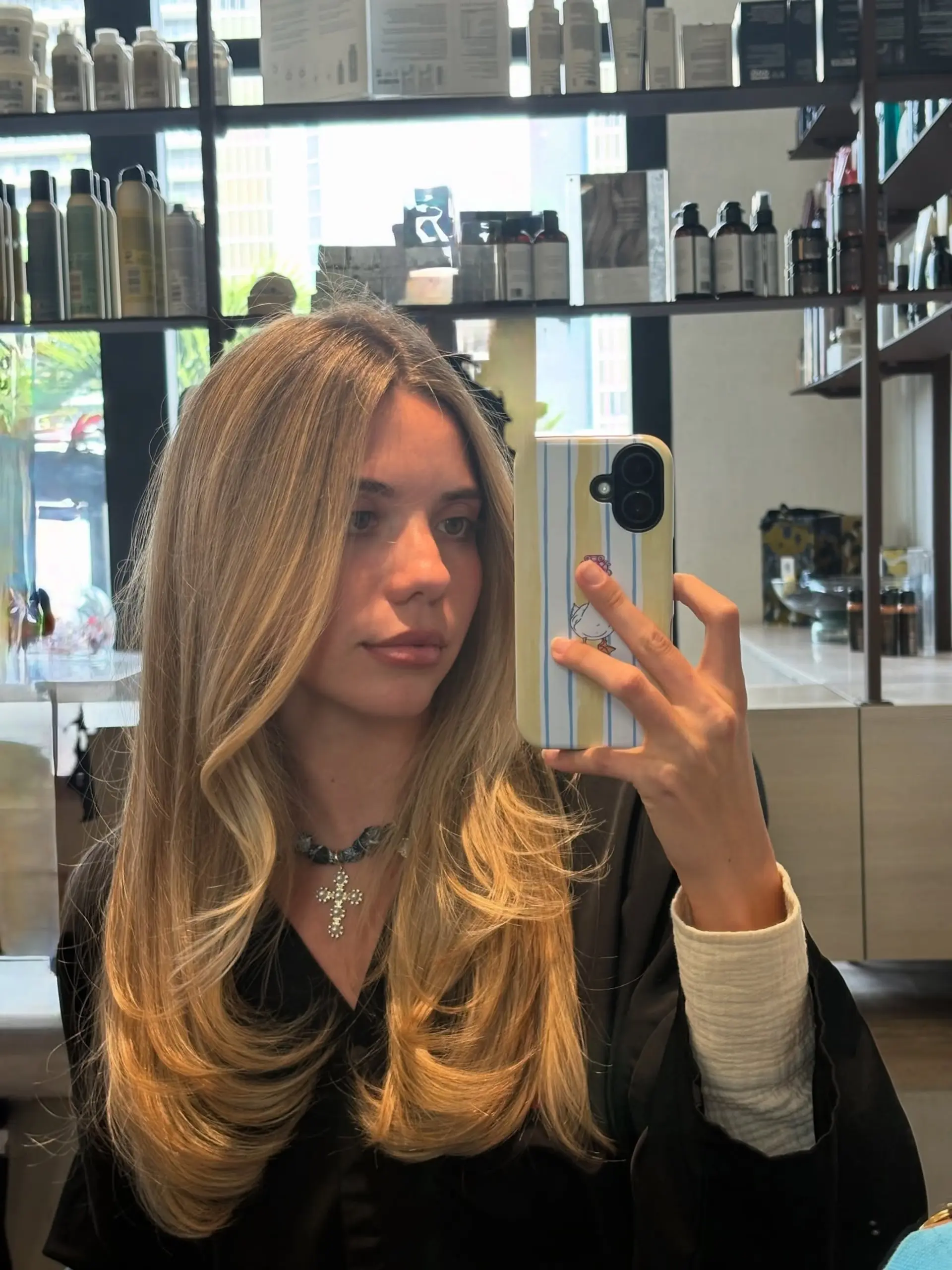 Long golden blonde balayage styled in voluminous face-framing layers with smooth, curved ends. 1