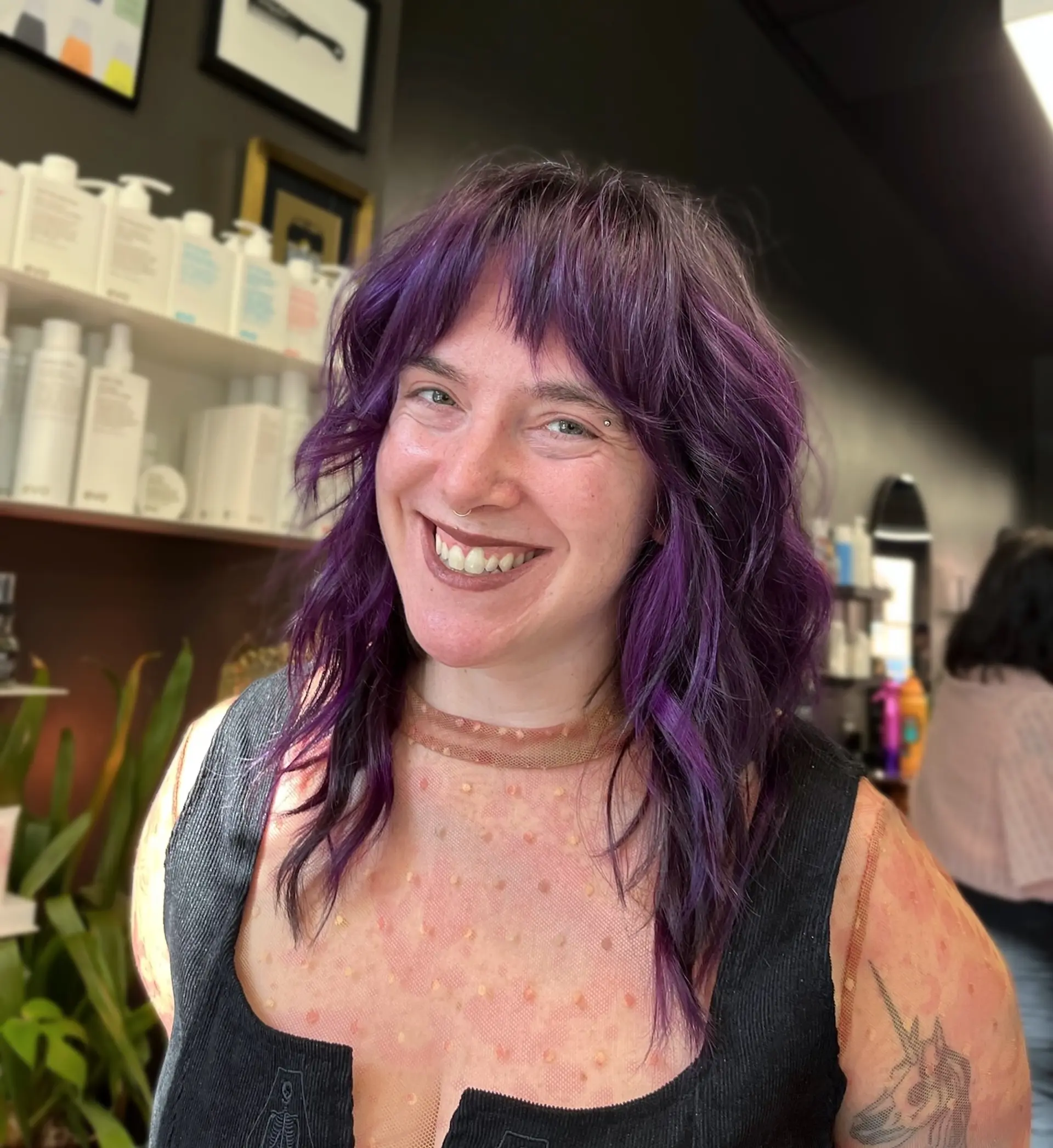 A layered, medium-length shag cut with wispy micro-bangs and soft textured waves, dyed in a rich, vibrant purple tone. 1
