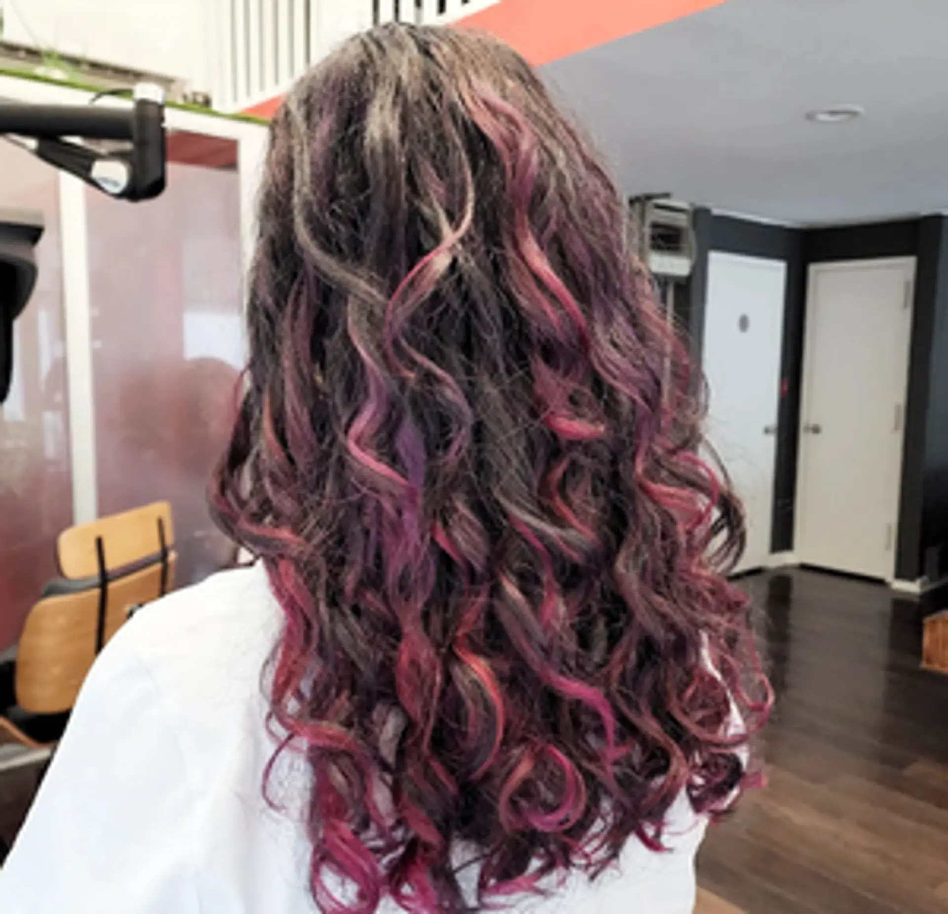 Elegantly long curly hair with a blend of dark brown, pink, and purple highlights, featuring long layers for added volume and depth. 1