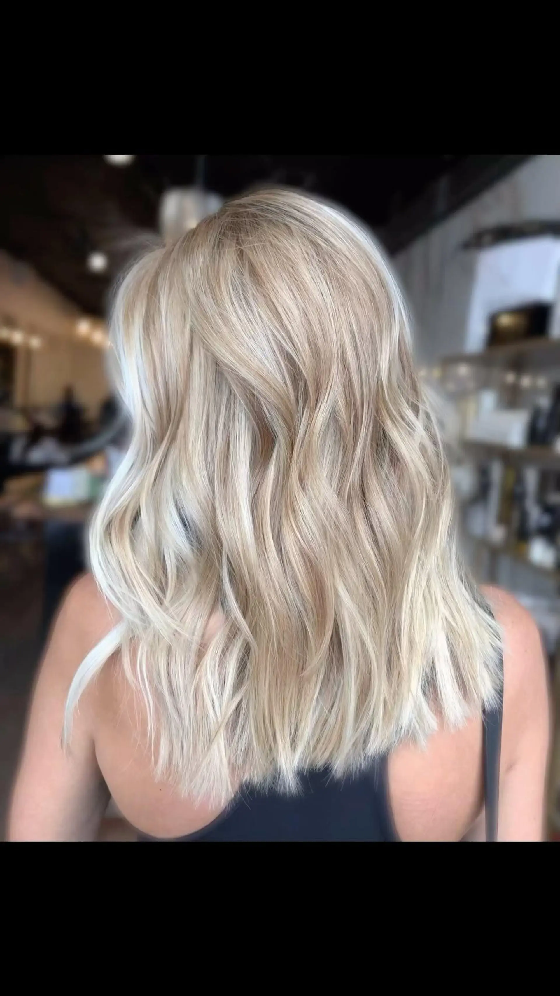 Shoulder-length bright blonde hair styled in soft, loose waves. 1