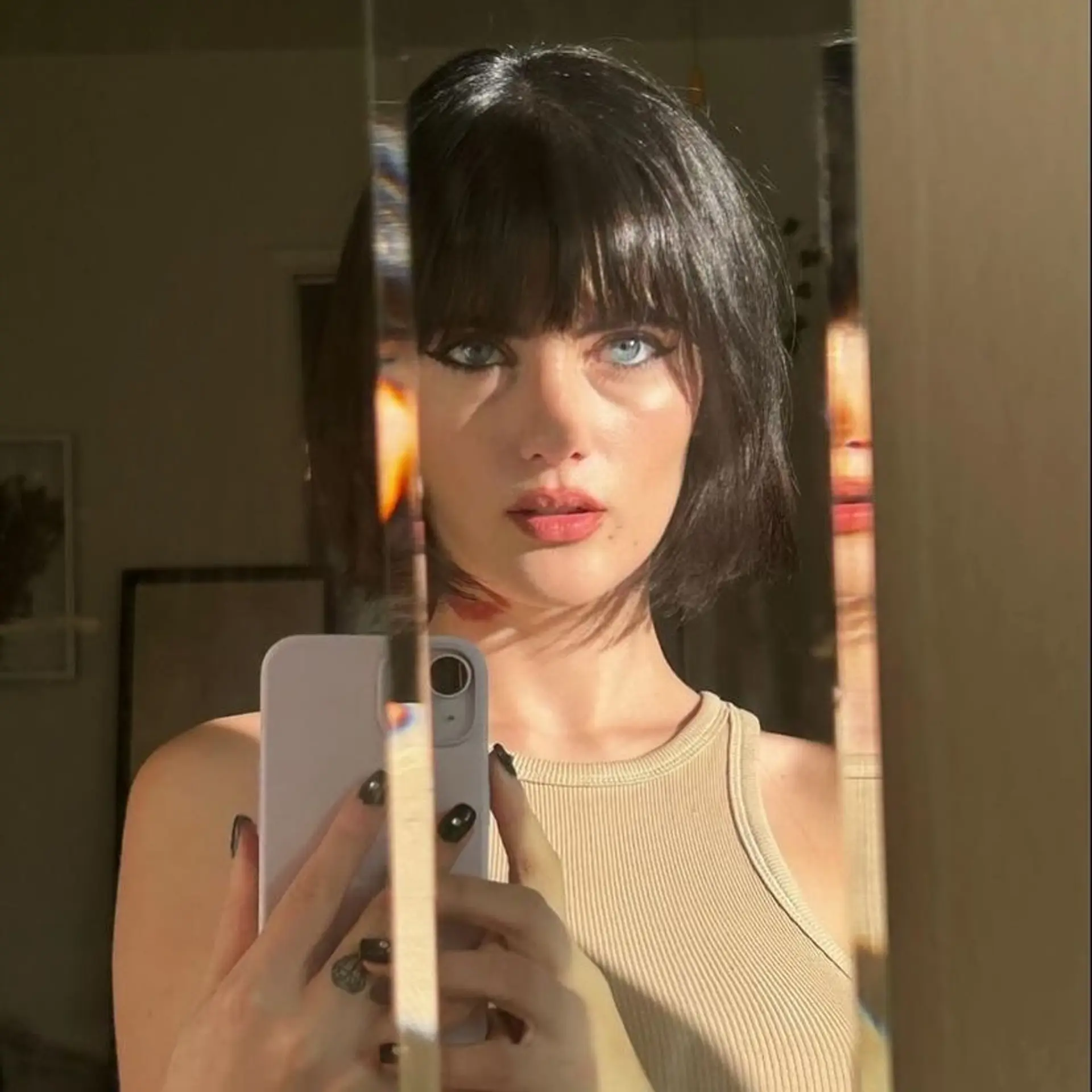 A sleek dark French bob cut with full straight bangs framing the face at chin length. 1