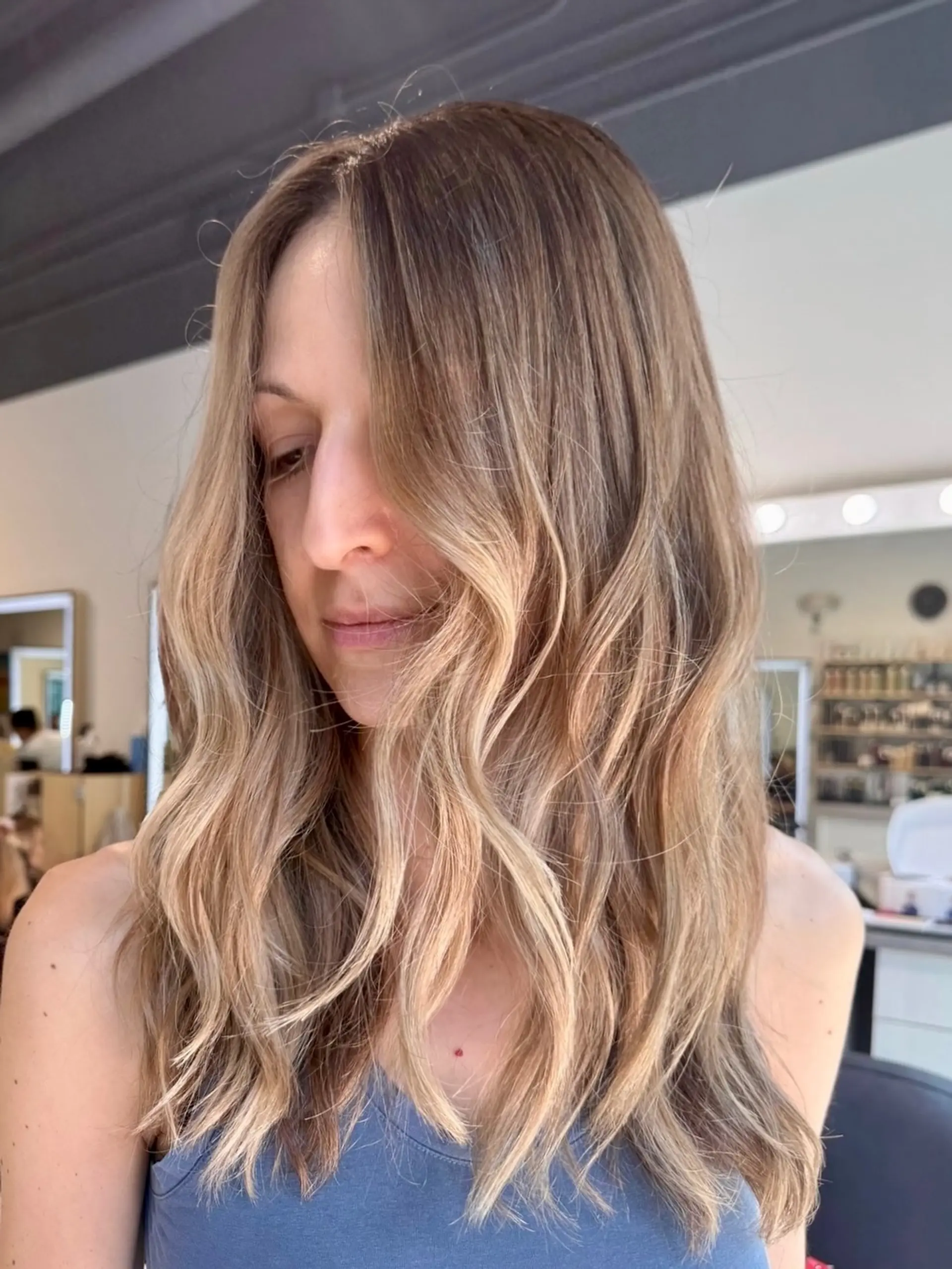 Soft, dimensional lived-in blonde styled with effortless, undone waves. 1