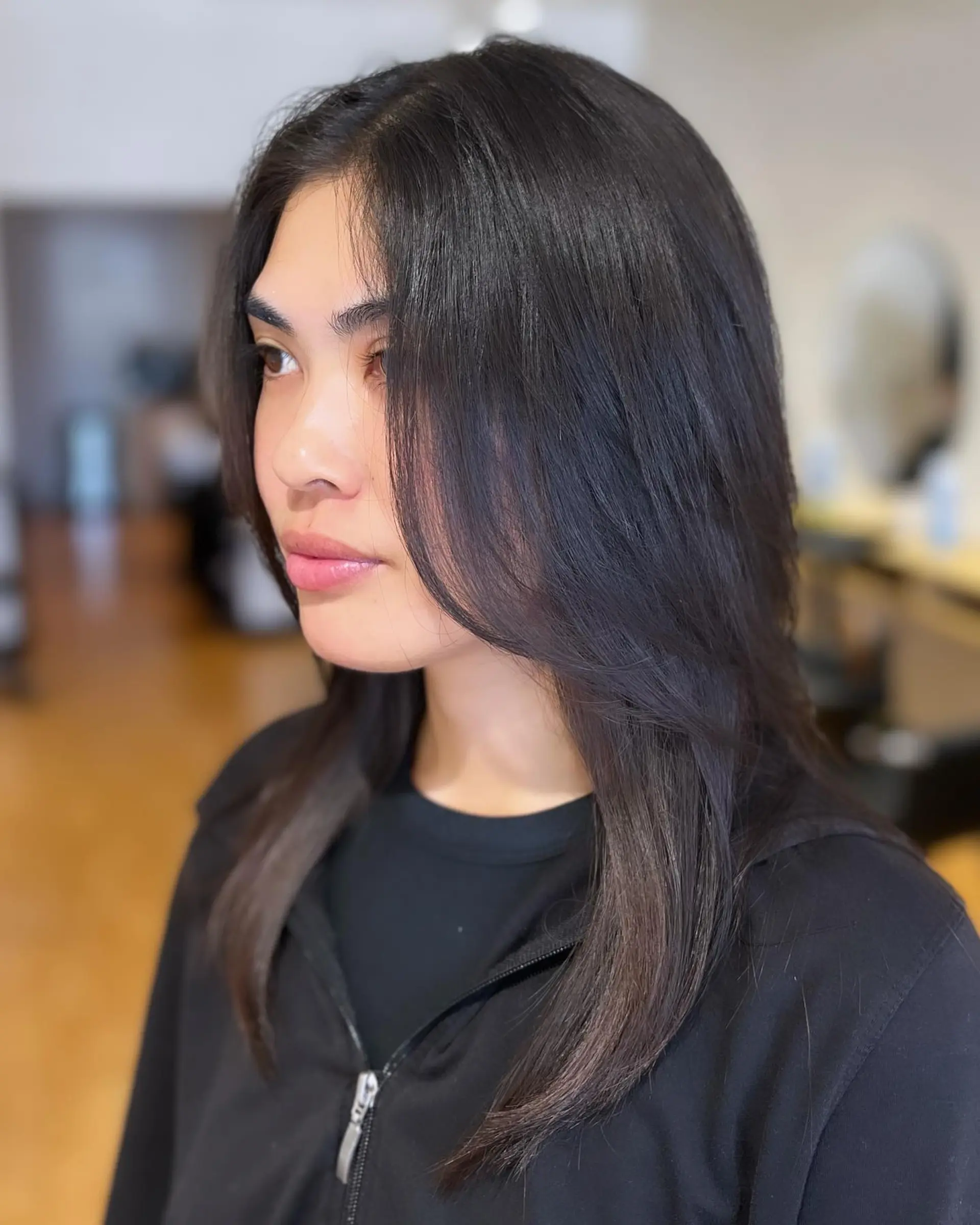 A medium-length straight hairstyle featuring soft, face-framing layers and a sleek, natural finish. 1