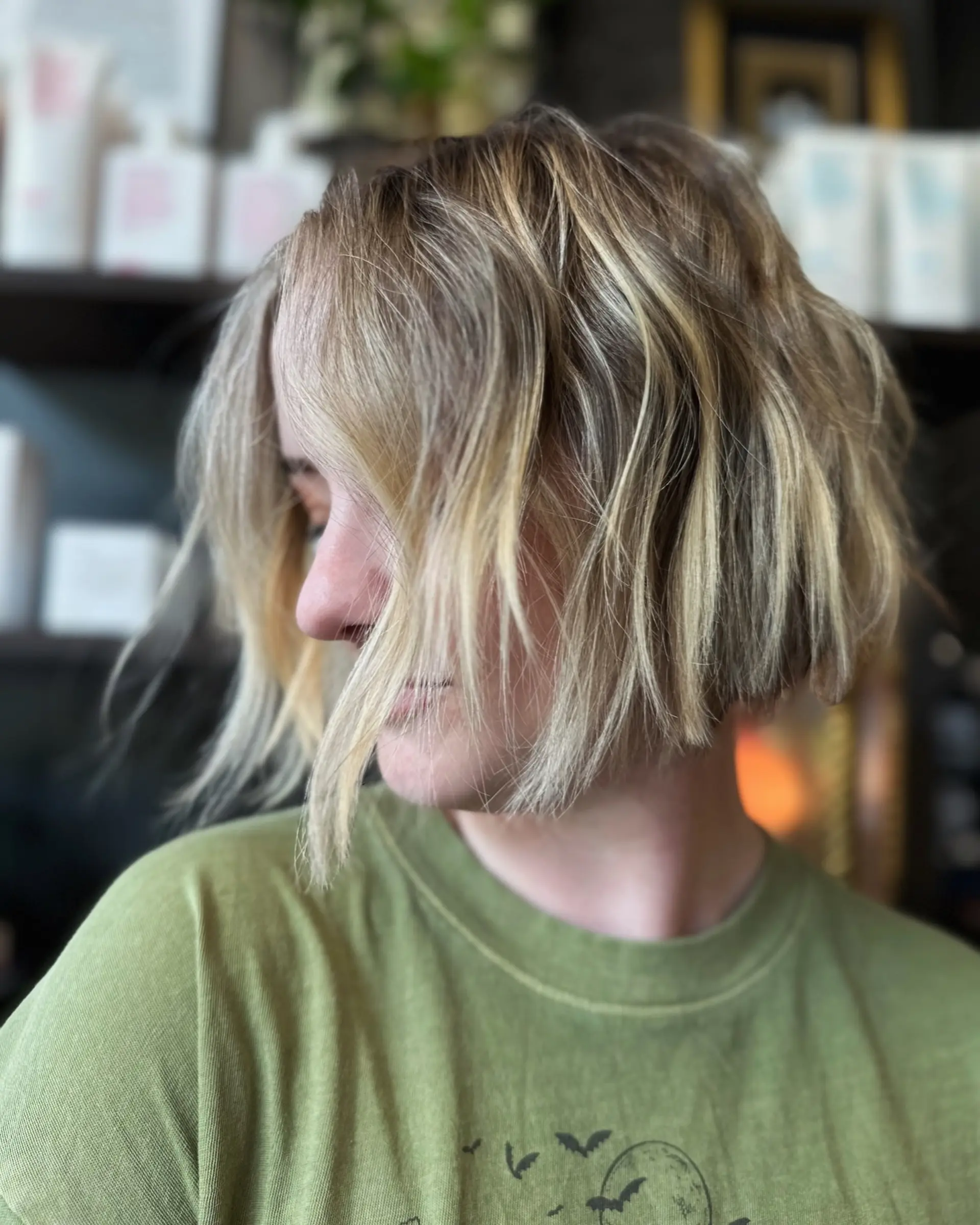A chin-length blunt bob featuring tousled piecey texture and multidimensional blonde tones. 1