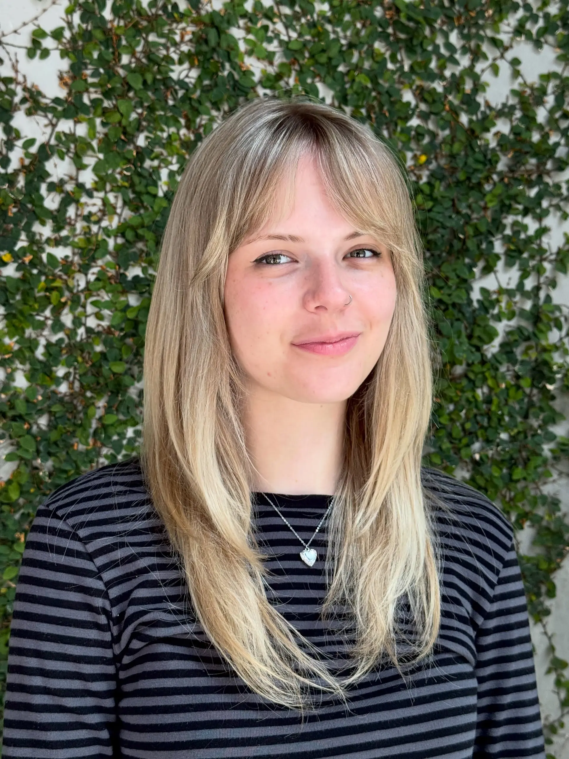 Straight long blonde hair featuring wispy curtain bangs and subtle face-framing layers. 1