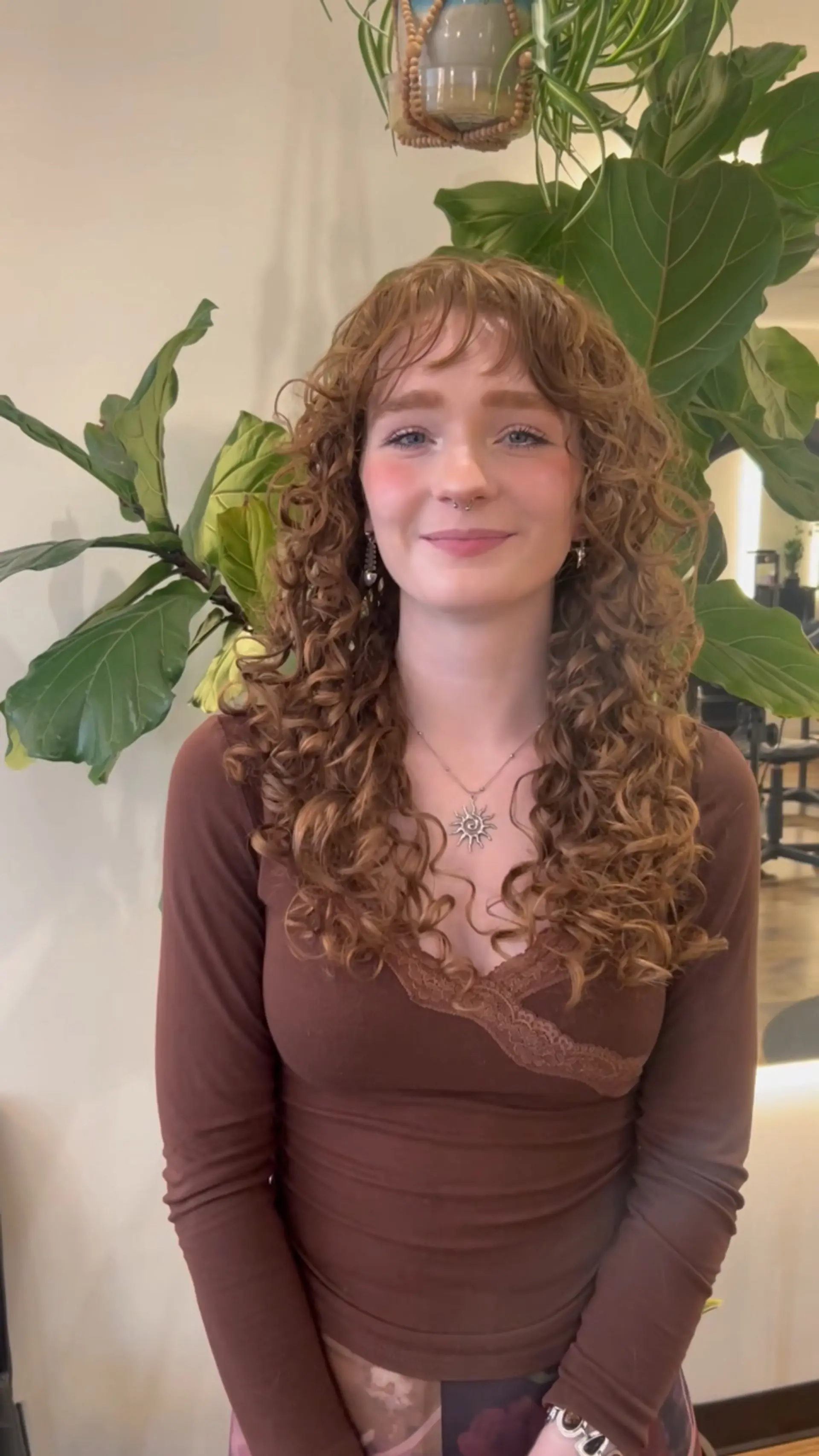 Voluminous long curly cut featuring defined ringlets, face-framing layers, and textured curly bangs. 1