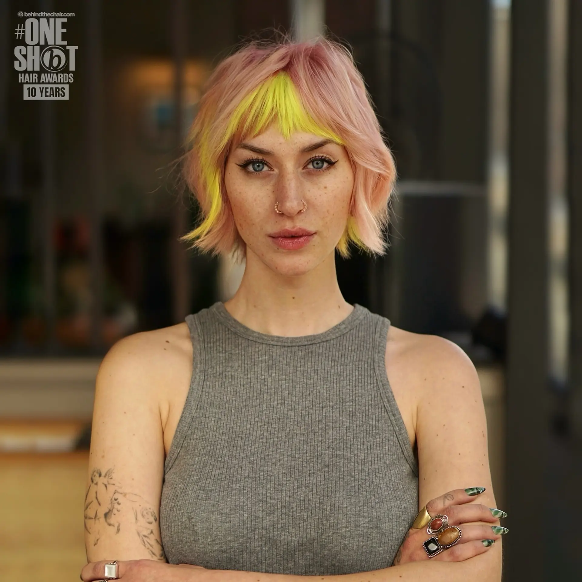 A textured pastel pink bixie haircut styled with bright neon yellow micro bangs and face-framing pieces. 1
