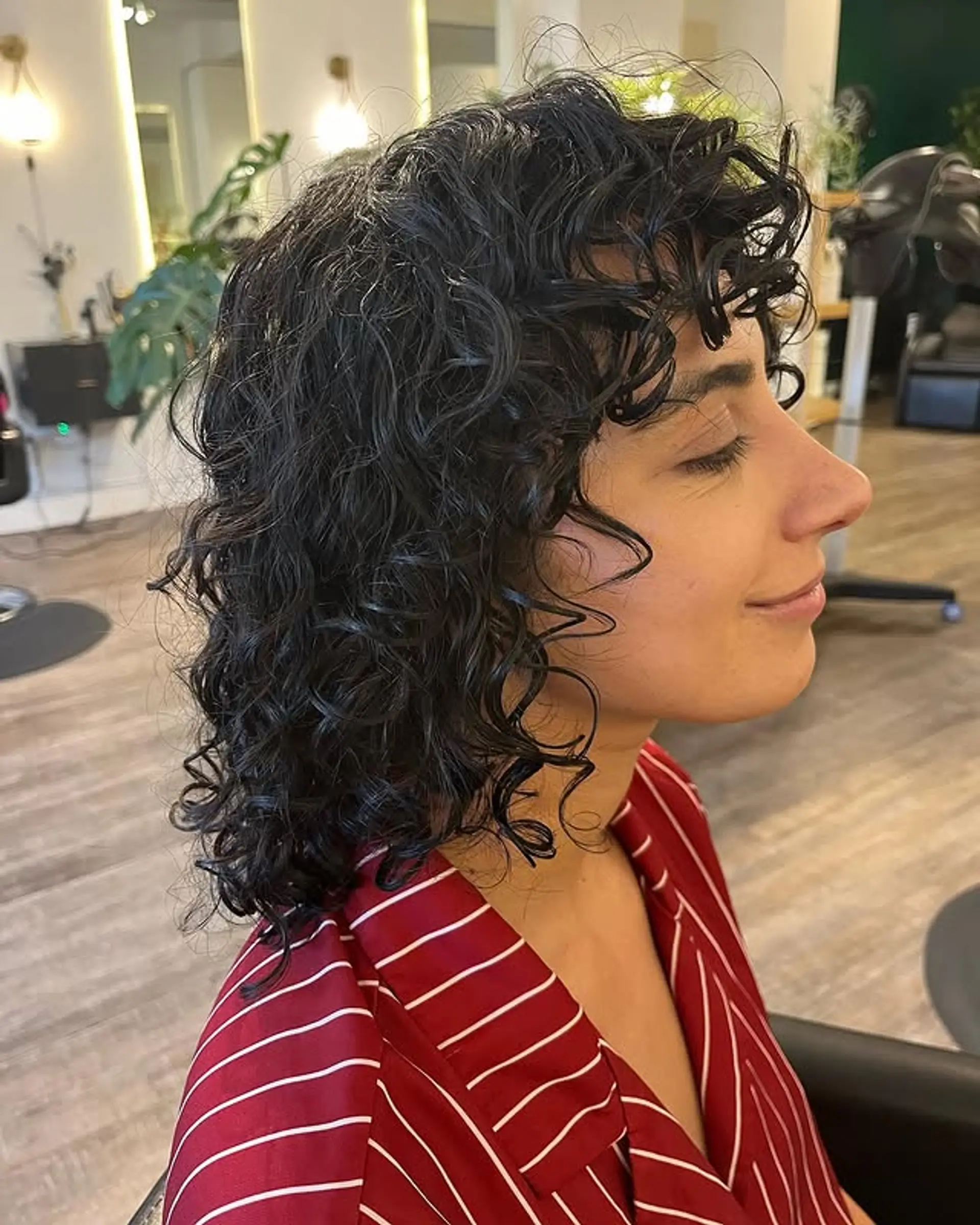 A curly shag haircut with textured layers and bangs. 1