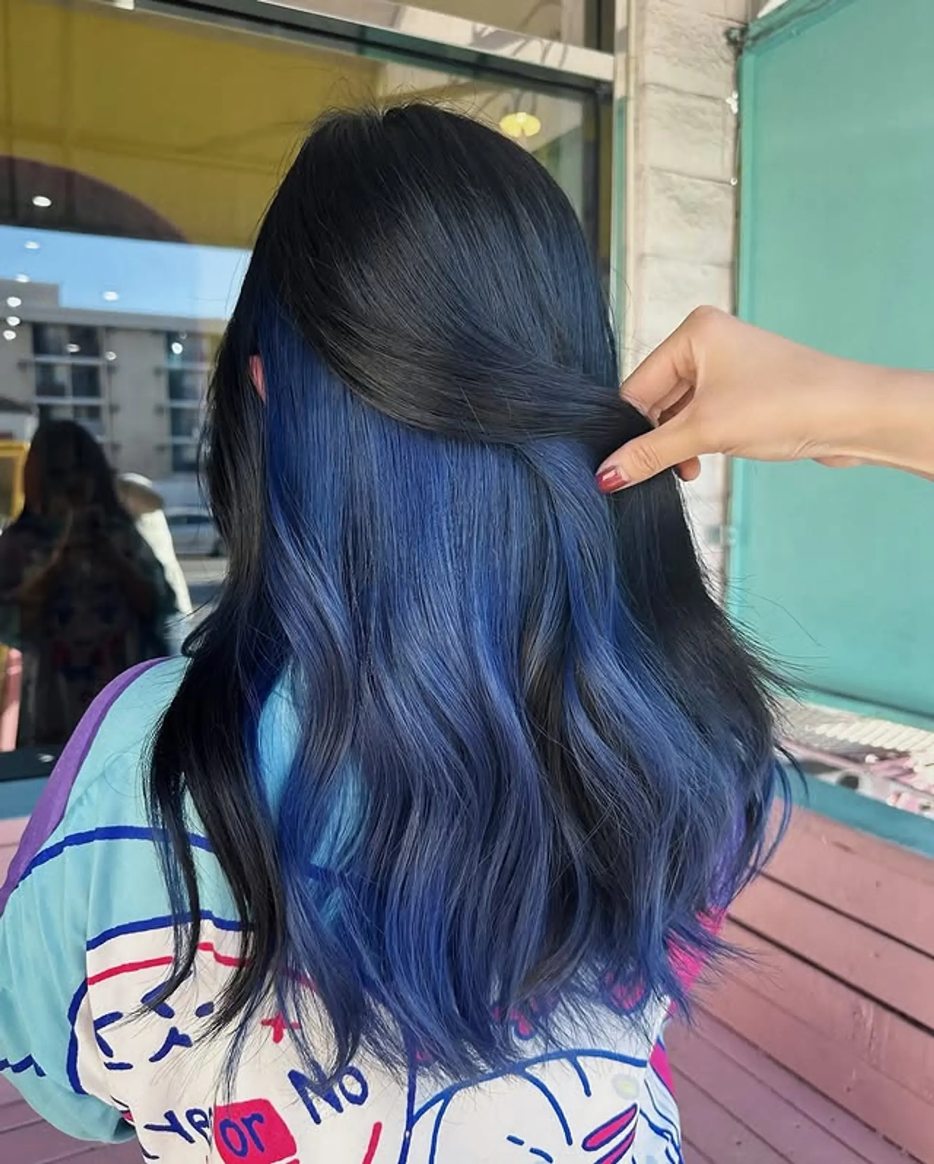 A long, wavy hairstyle with a secret layer of color underneath, creating a surprising and stylish contrast. 1