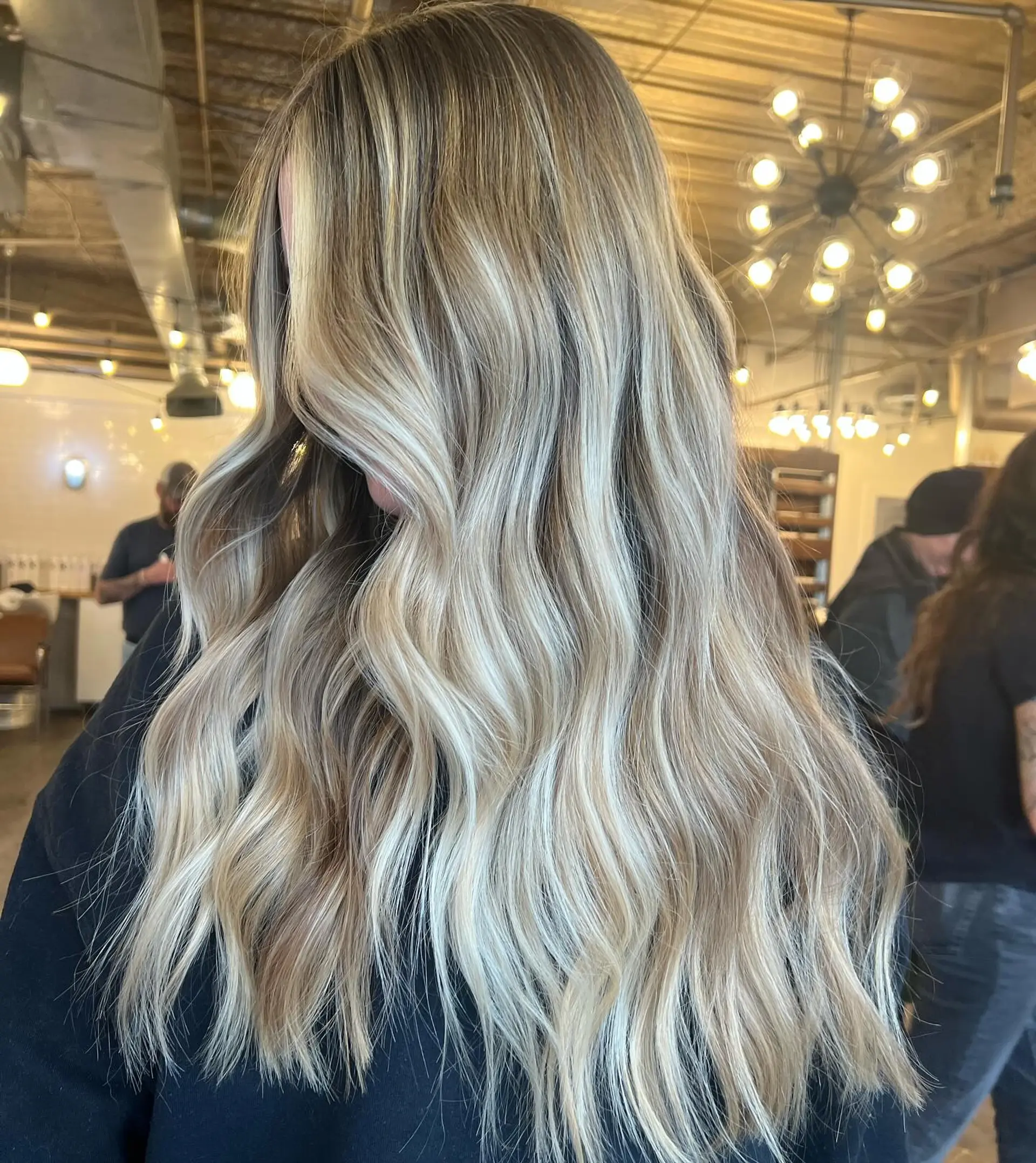 Long dimensional blonde hair styled in soft, cascading beach waves. 1
