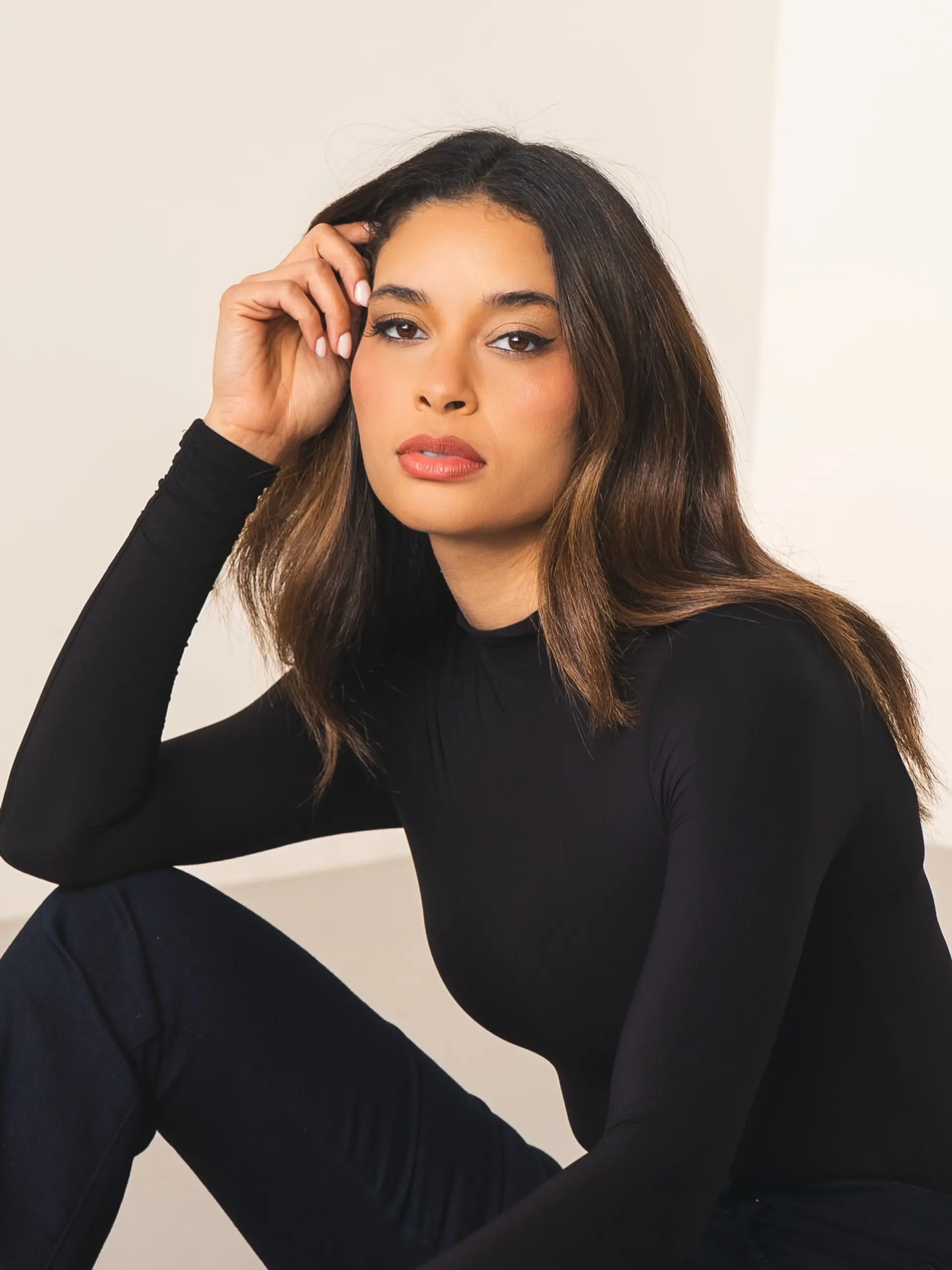 Rich brunette hair featuring soft hand-painted highlights and styled with loose, polished waves. 1