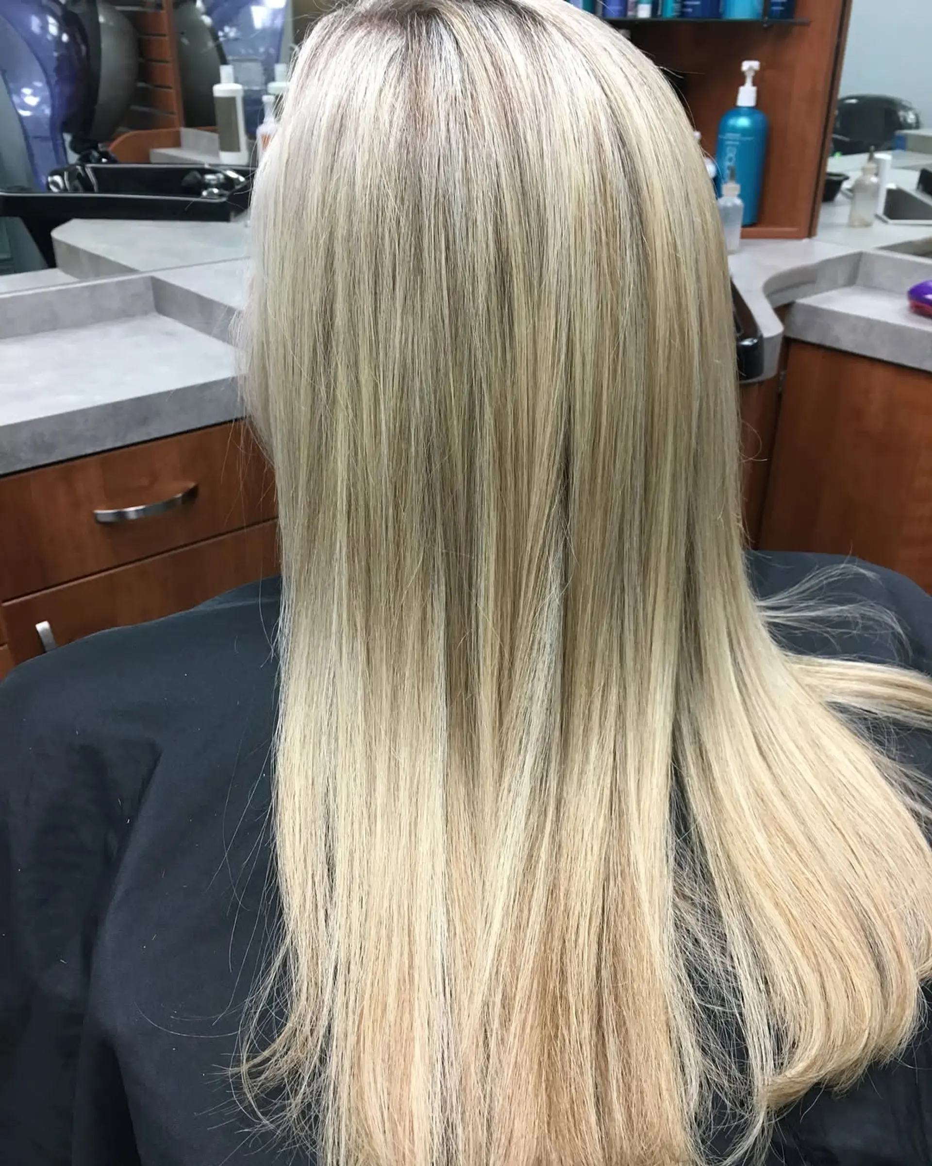 Long, sleek straight blonde hair with multi-tonal highlights seamlessly blended from roots to ends. 1