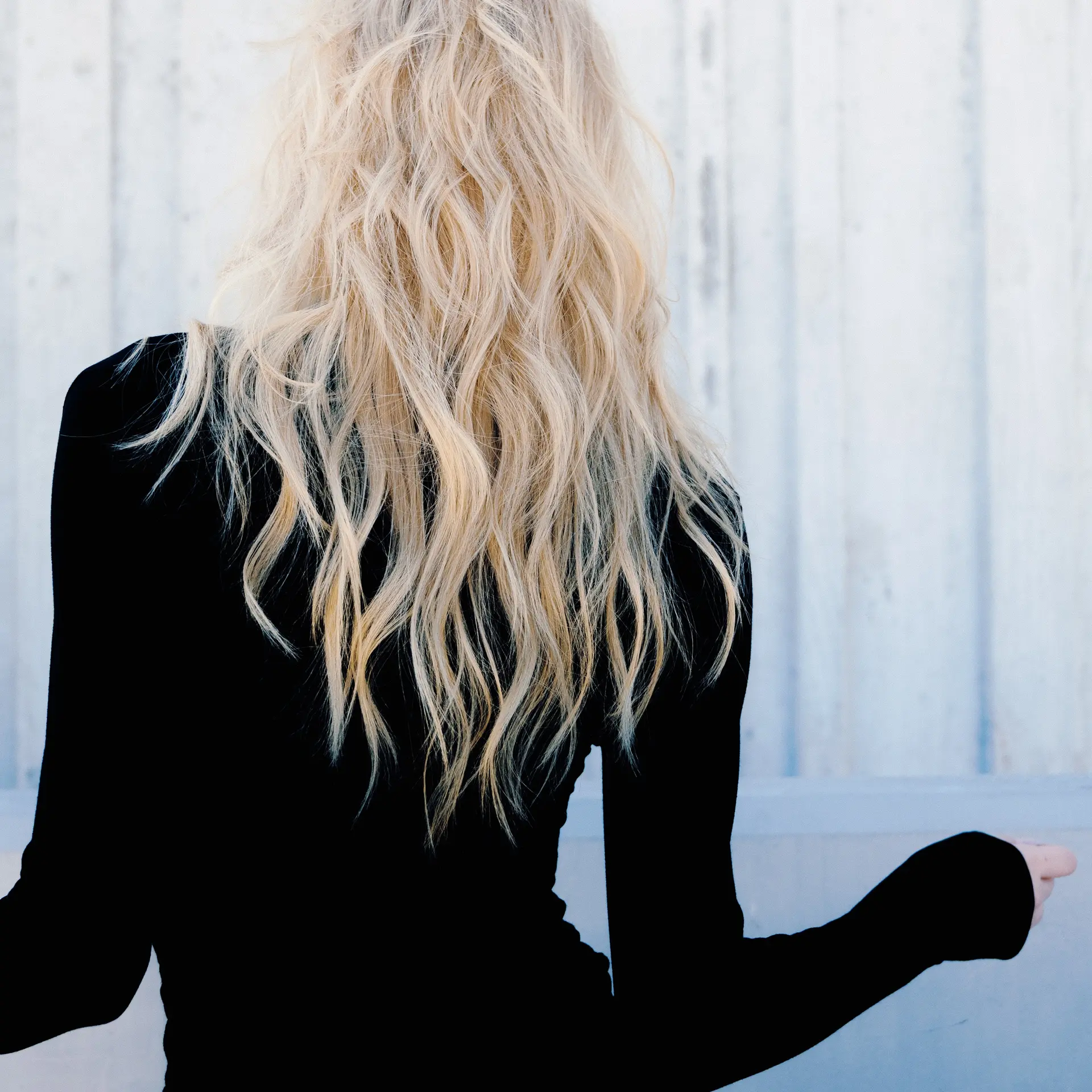 Long blonde hair cut with soft textured layers and styled in effortless, piecey waves. 1
