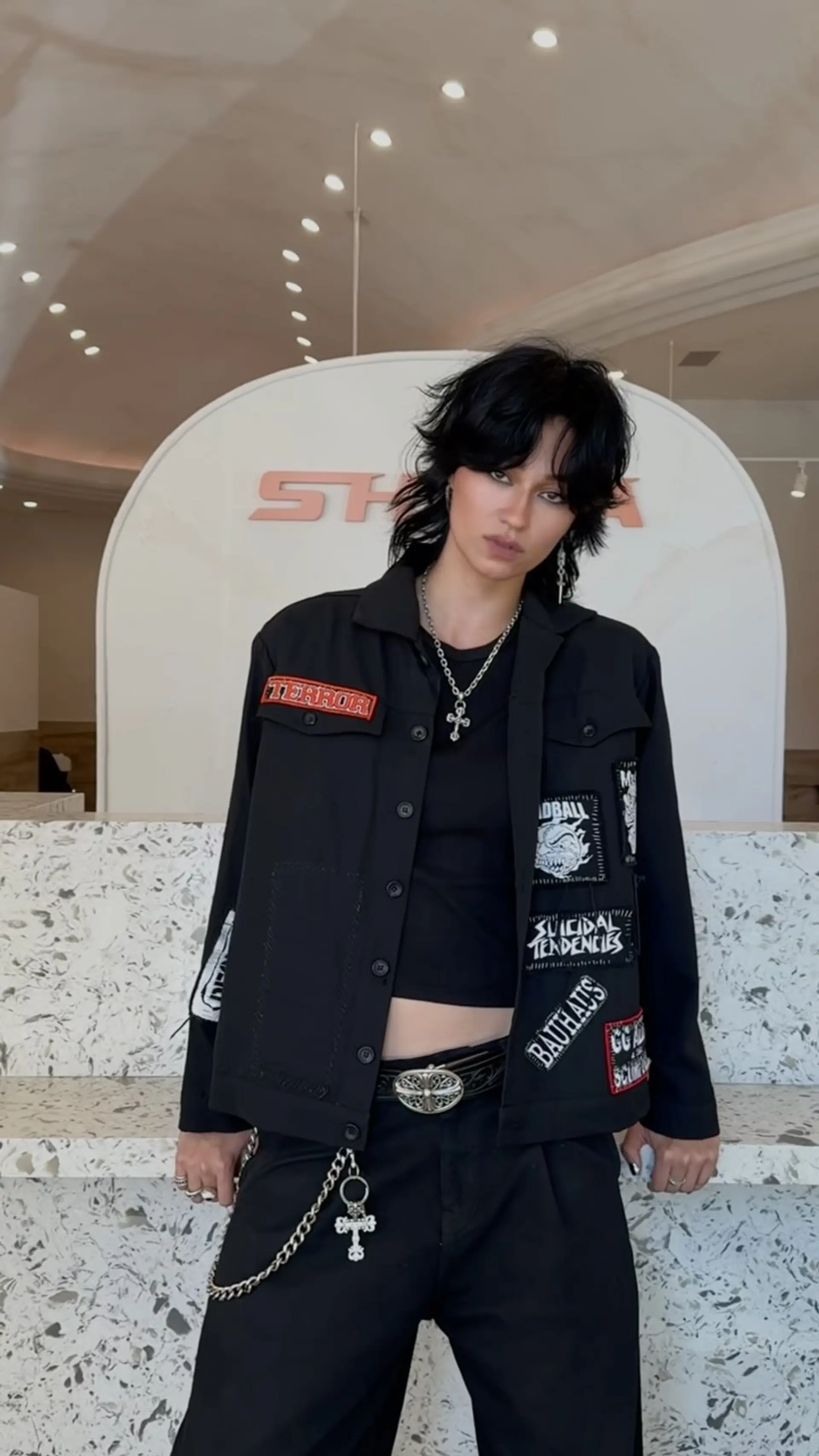 A heavily layered, choppy jet black wolf cut with feathered bangs and textured volume around the crown. 1