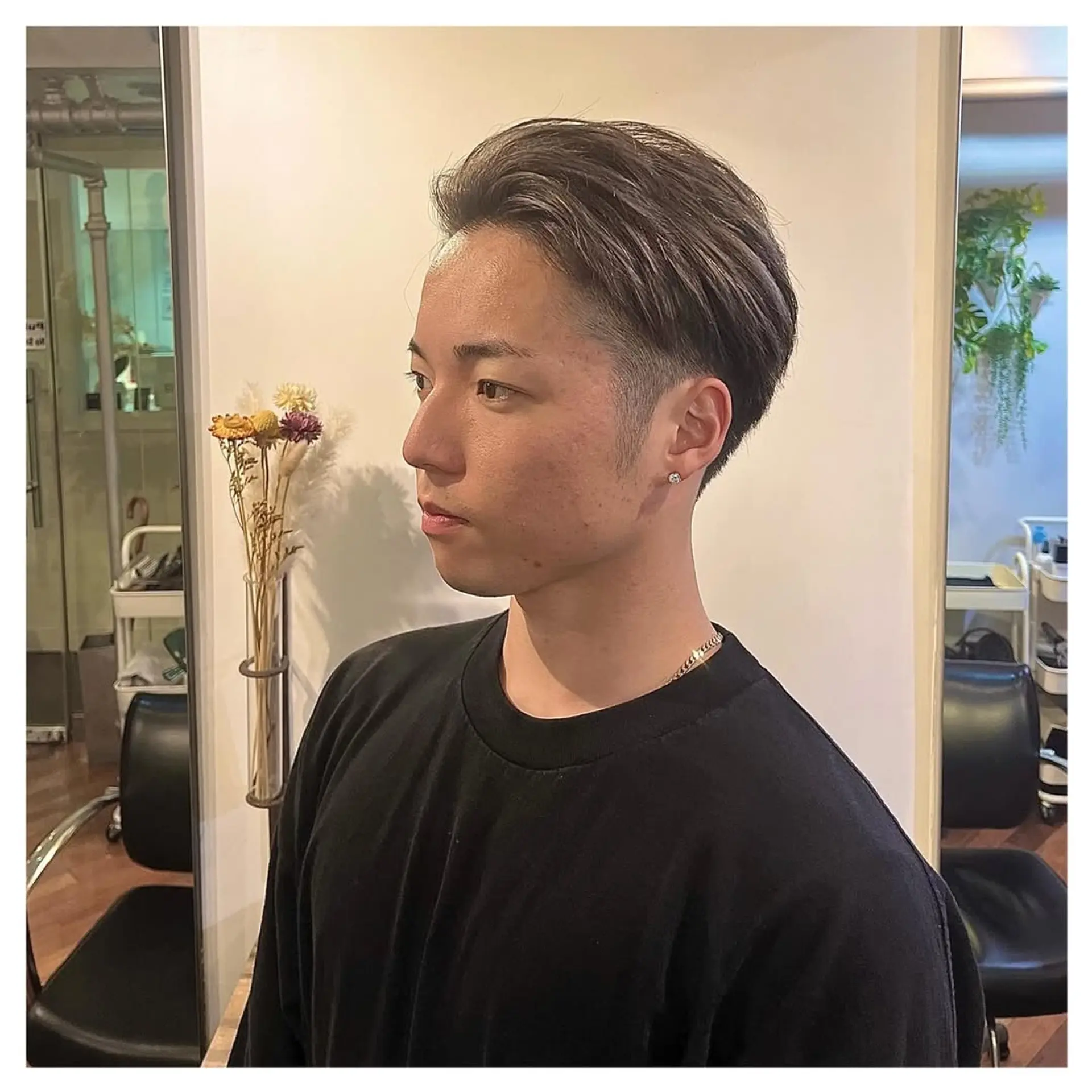 Features a short, faded haircut with textured top and modern silver highlights. 1