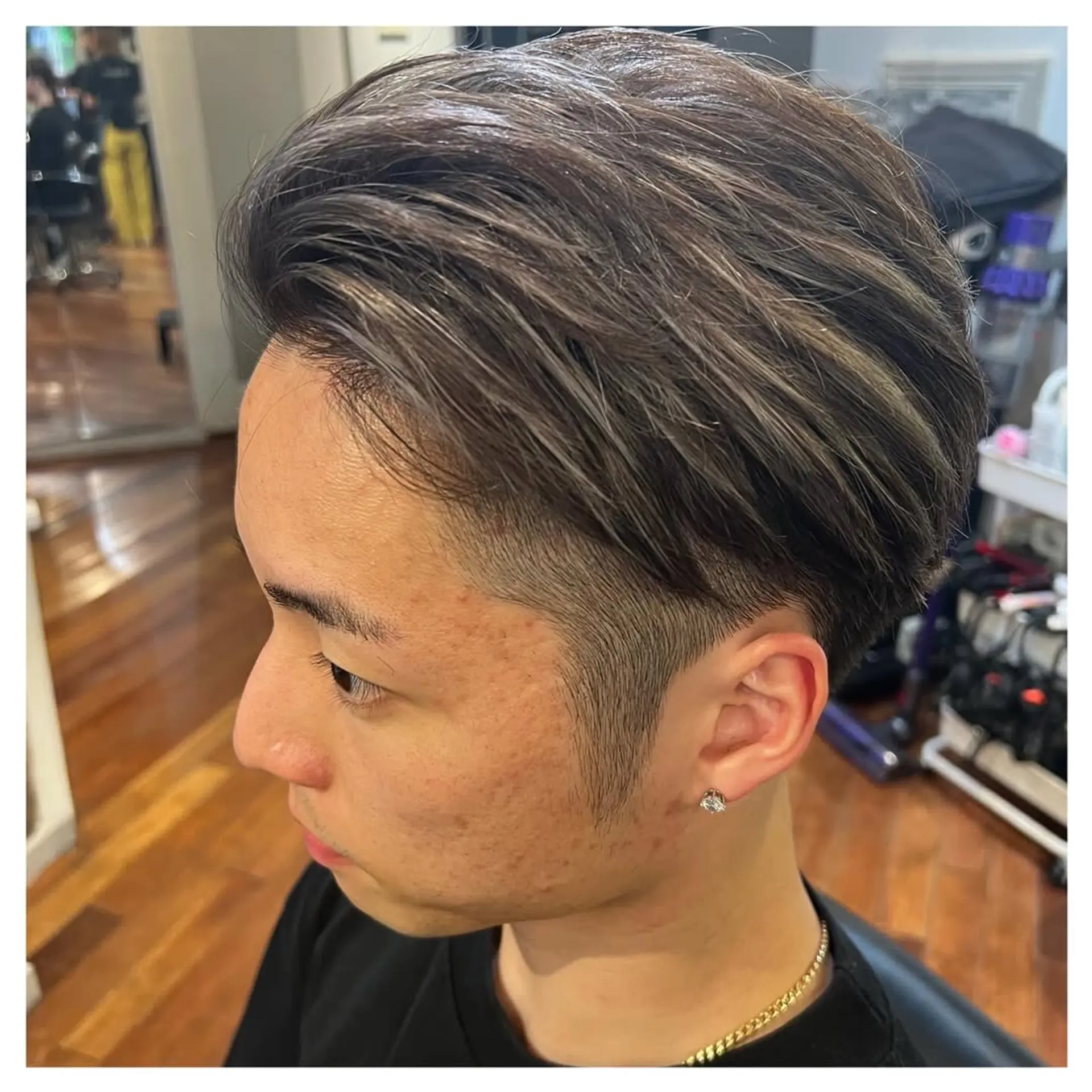Features a short, faded haircut with textured top and modern silver highlights. 2