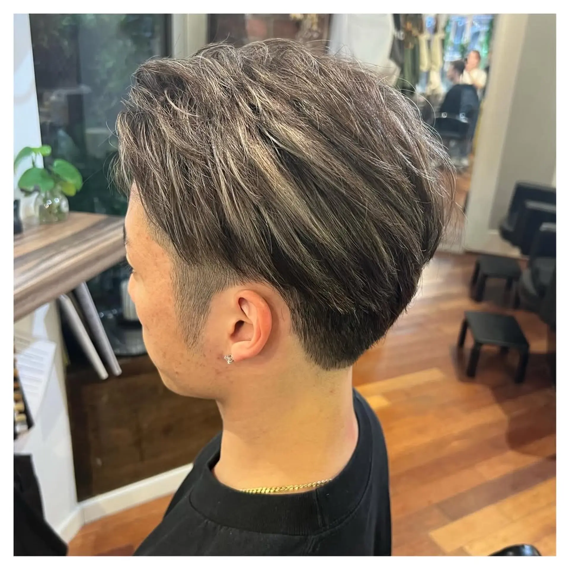 Features a short, faded haircut with textured top and modern silver highlights. 5