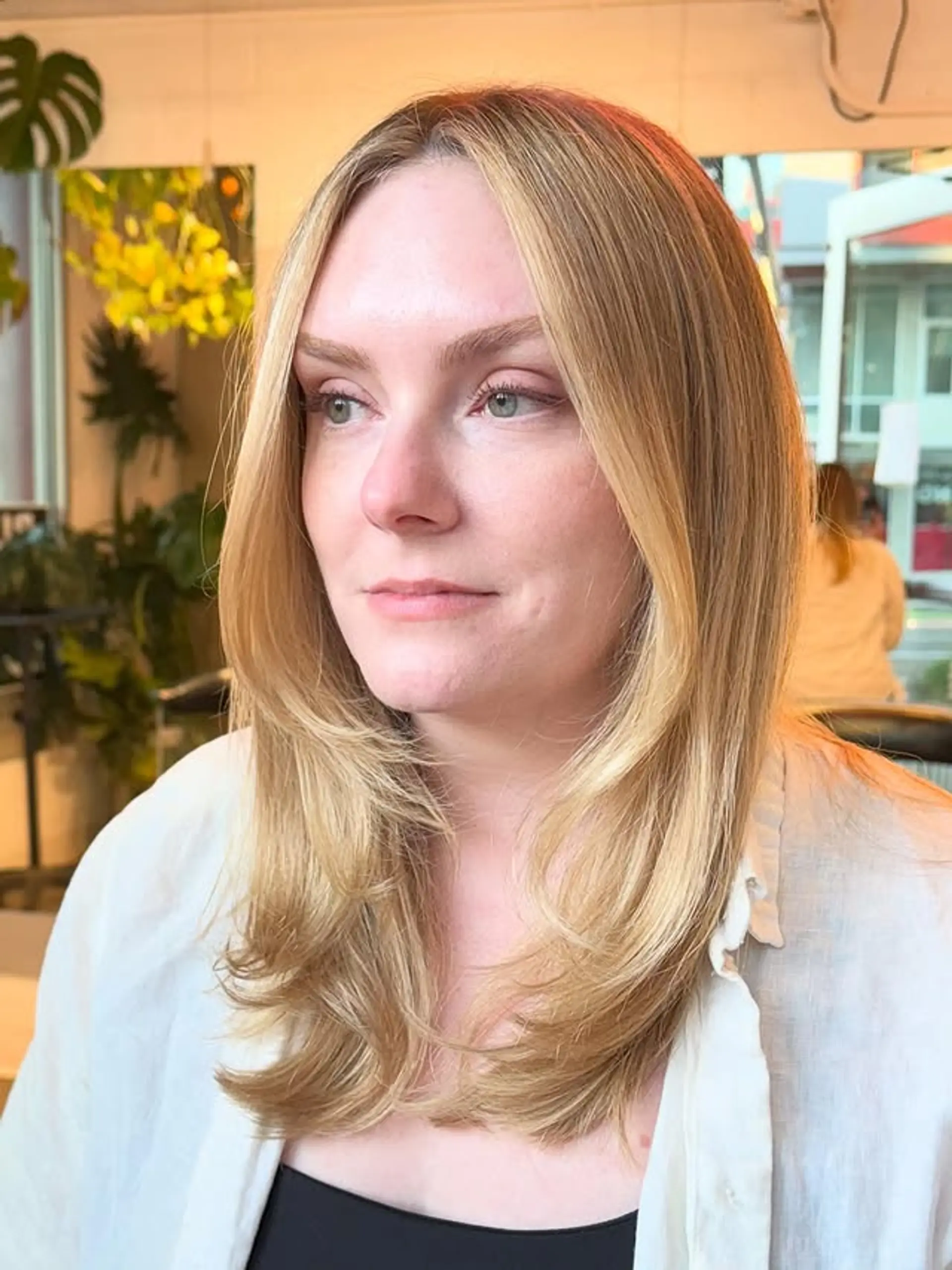 A layered medium-length hairstyle with face-framing layers and curtain bangs. 1