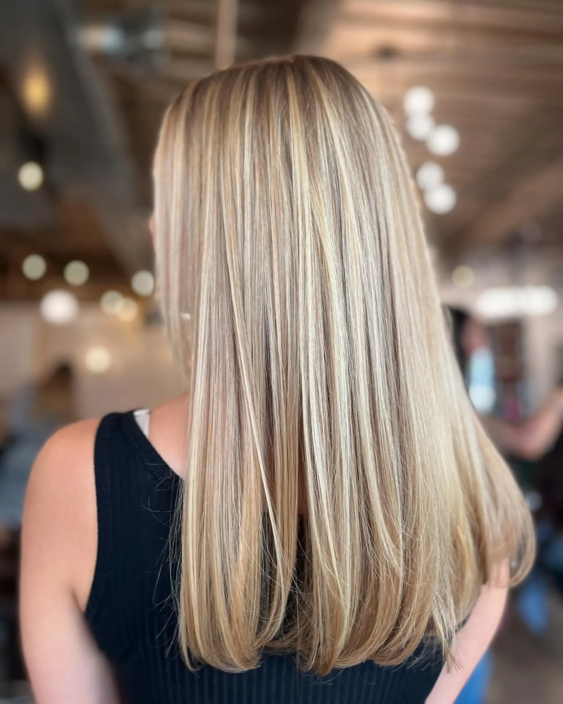 Long, sleek straight hair with soft inward-curving ends and fine multi-dimensional blonde highlights. 1