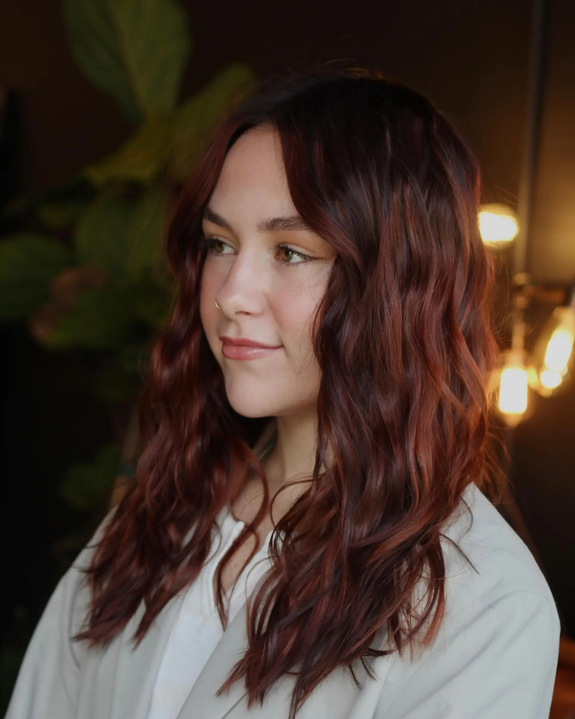 Long dimensional soft copper and auburn hair styled in effortless loose waves with a center part. 1