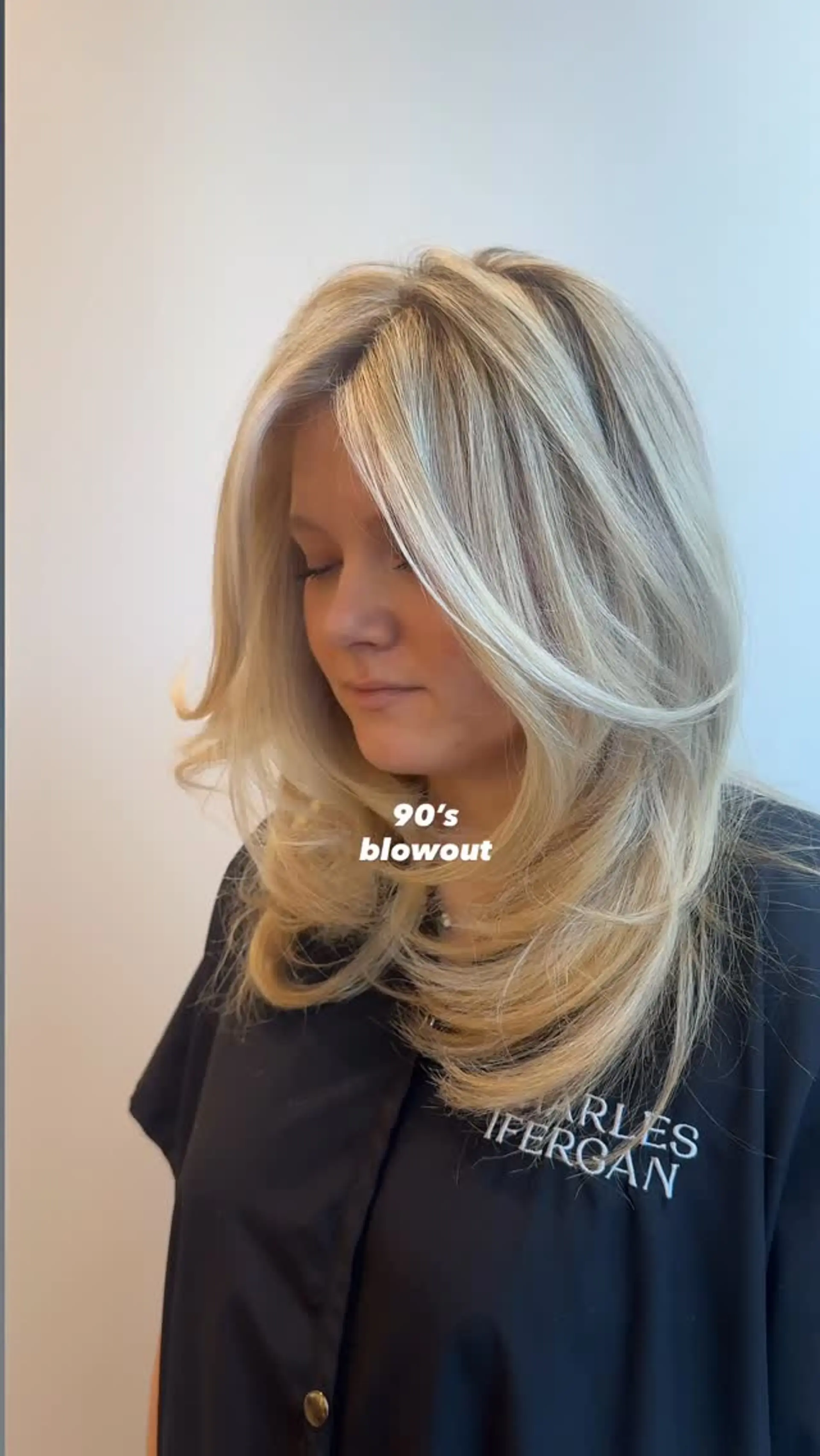 A voluminous 90s-inspired blowout featuring long, feathered face-framing layers curled gently inward. 1