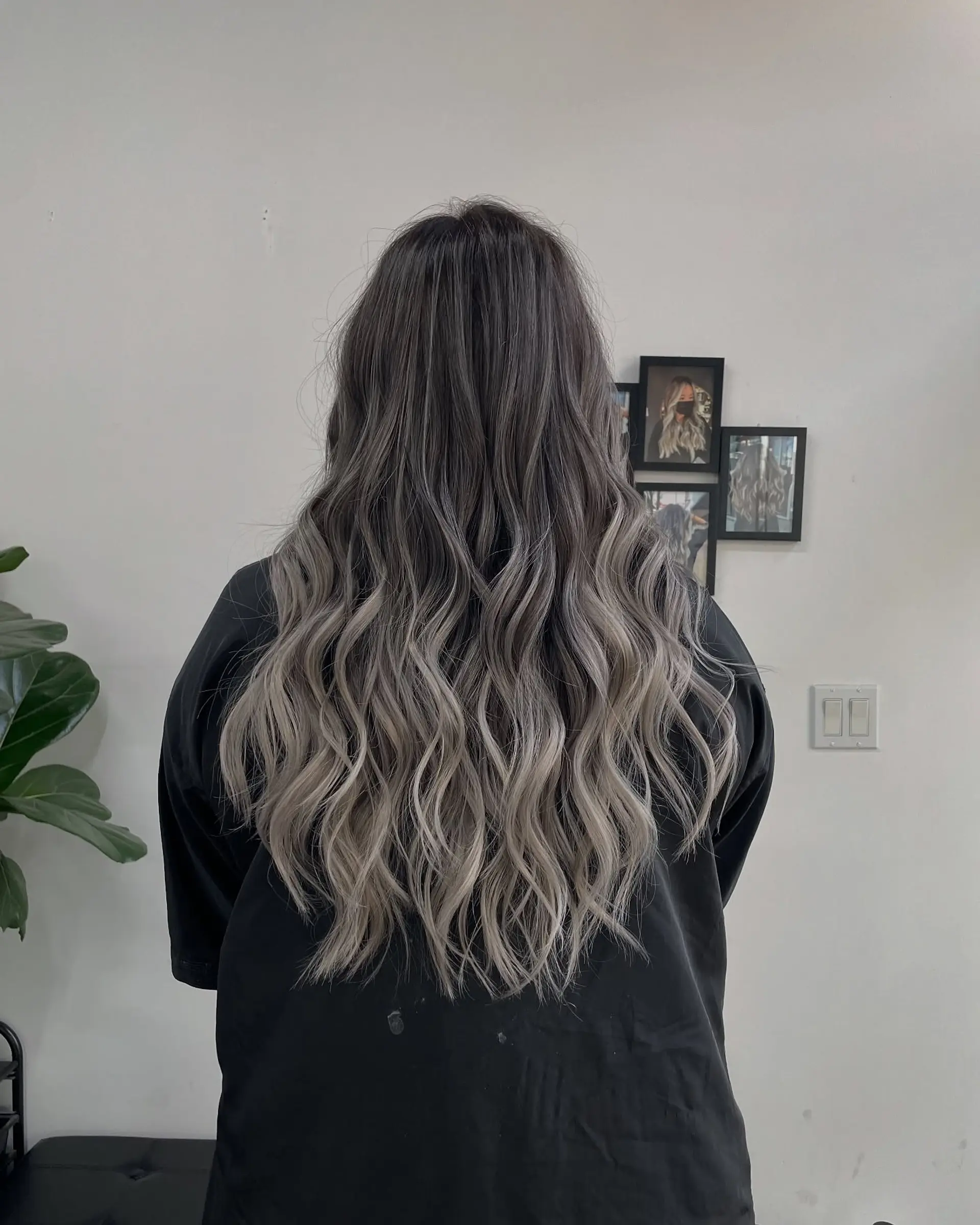 Long, wavy hairstyle with a beautiful balayage that transitions from dark roots to ash blonde. 1