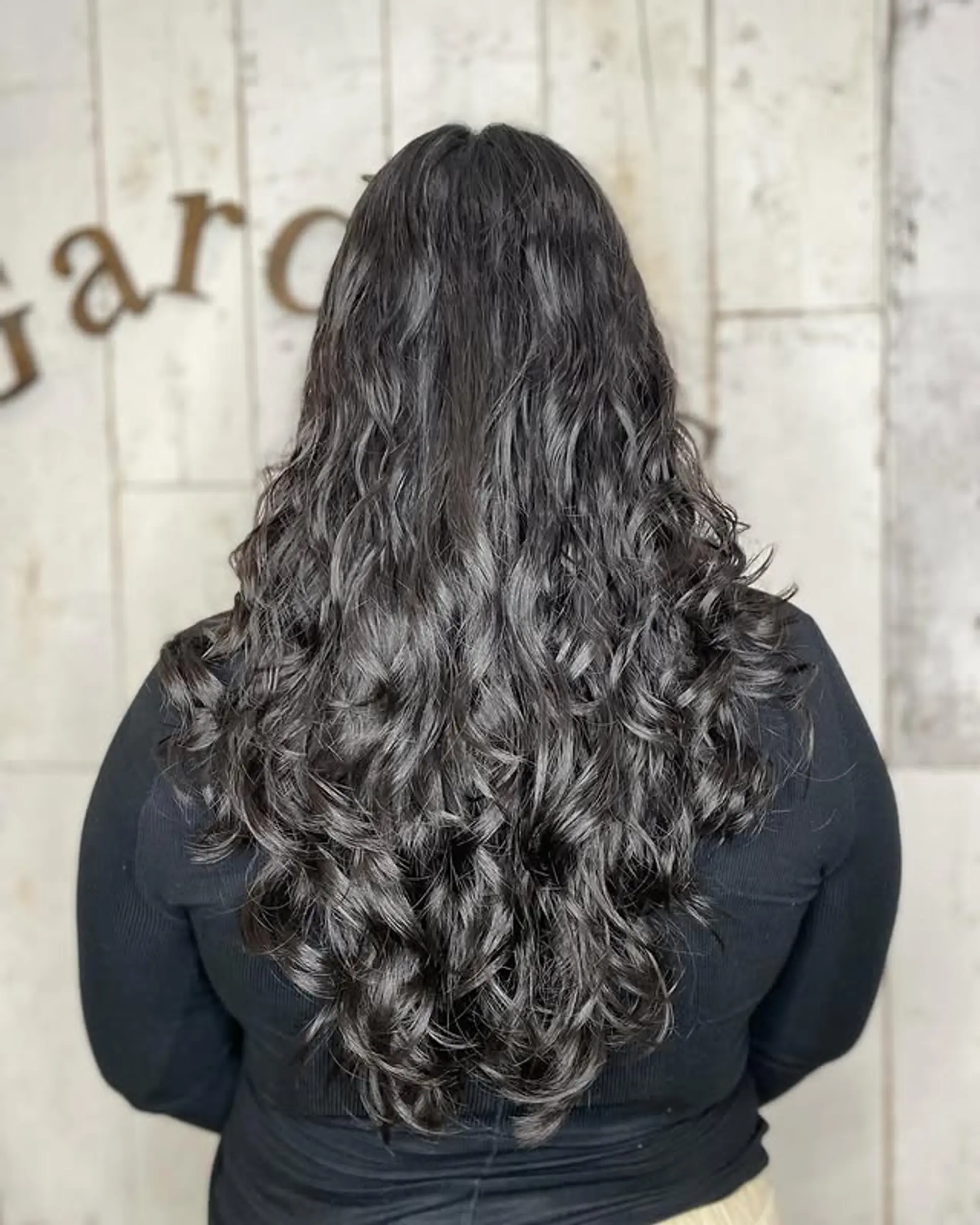 Long layered haircut with defined curls. 1