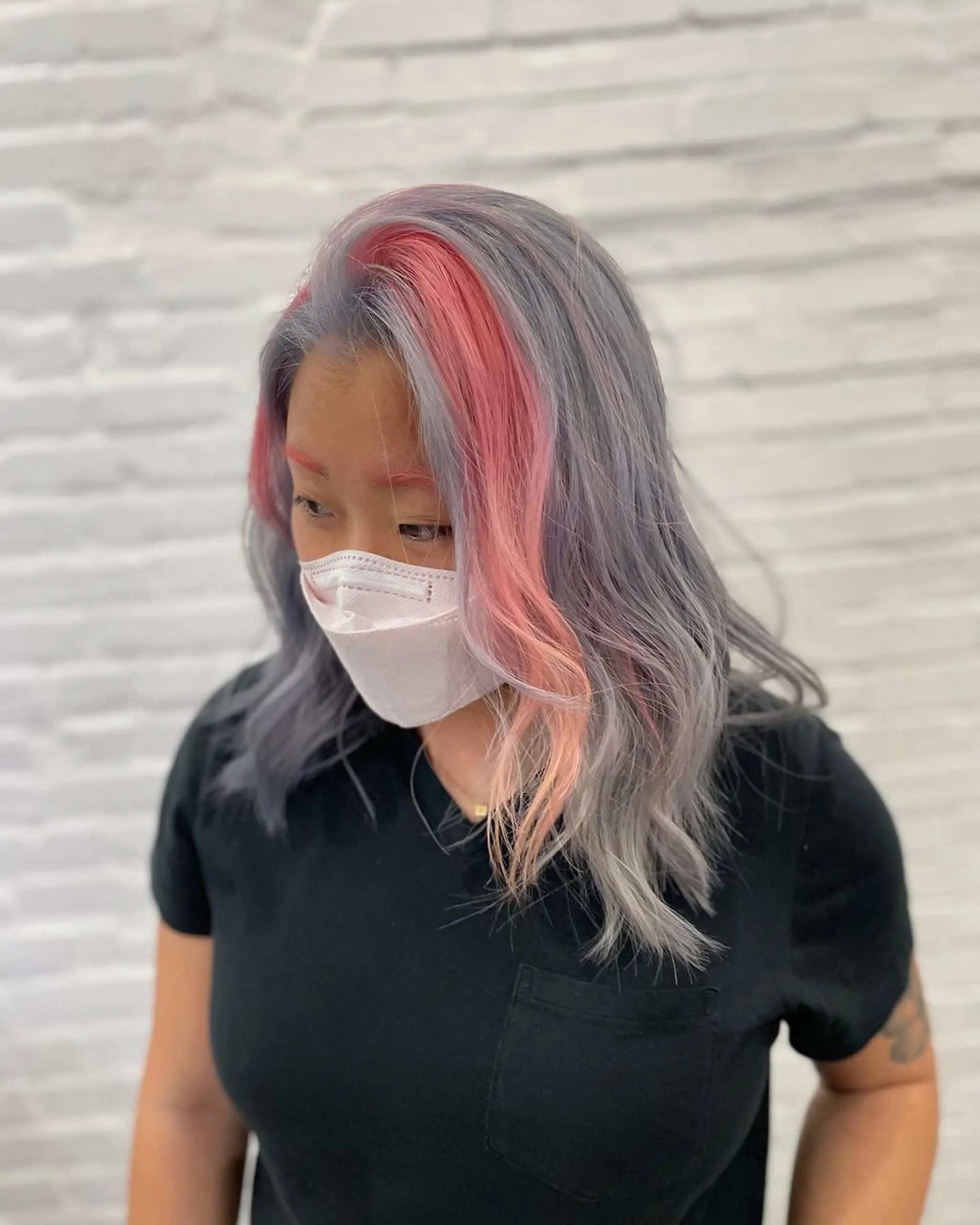 Medium-length, wavy hair with a pastel ombre mix of pink, purple, and silver colors.