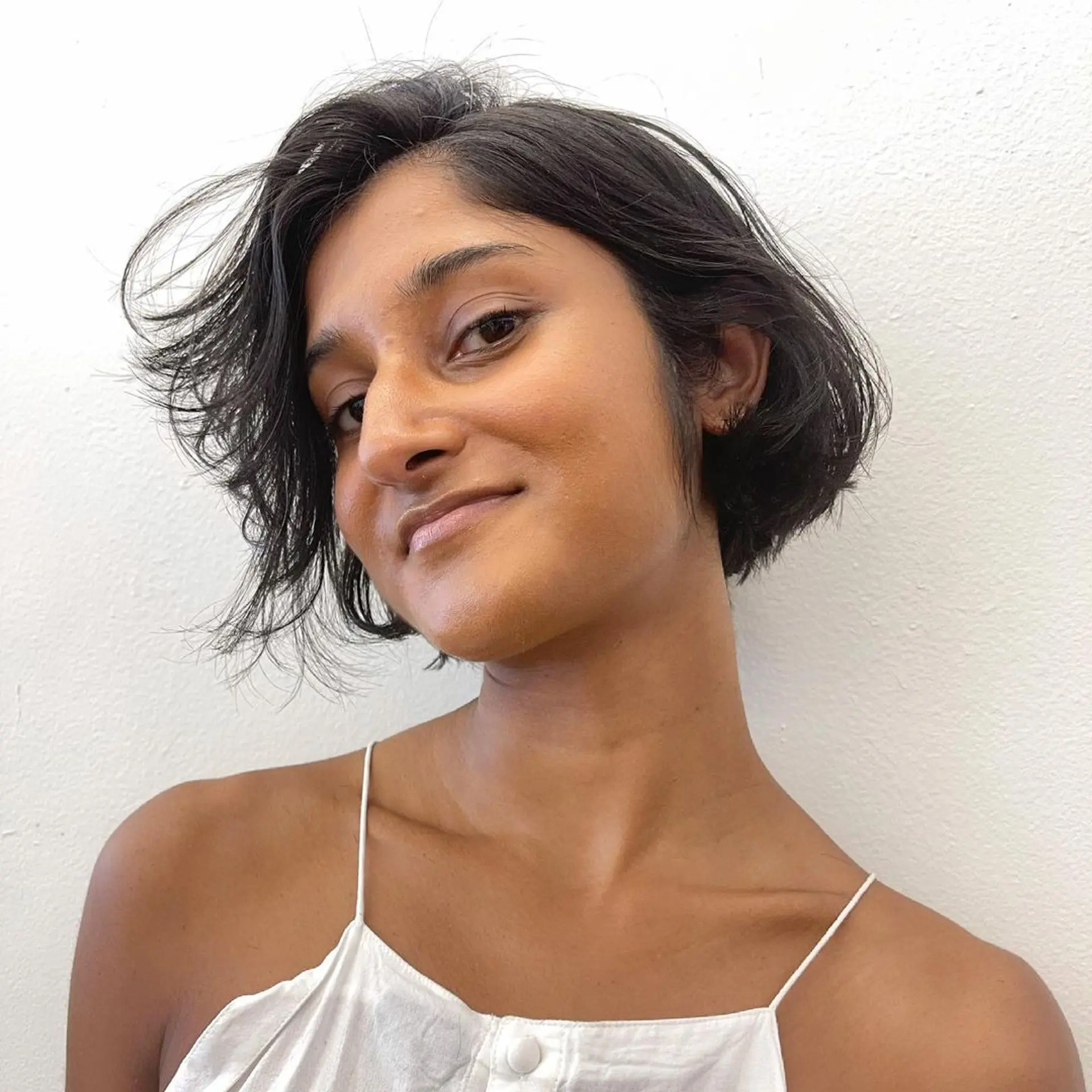 Short, chic tousled bixie cut (Pixie + Bob) with a natural wave and textured ends, creating a casual and effortless look. 2