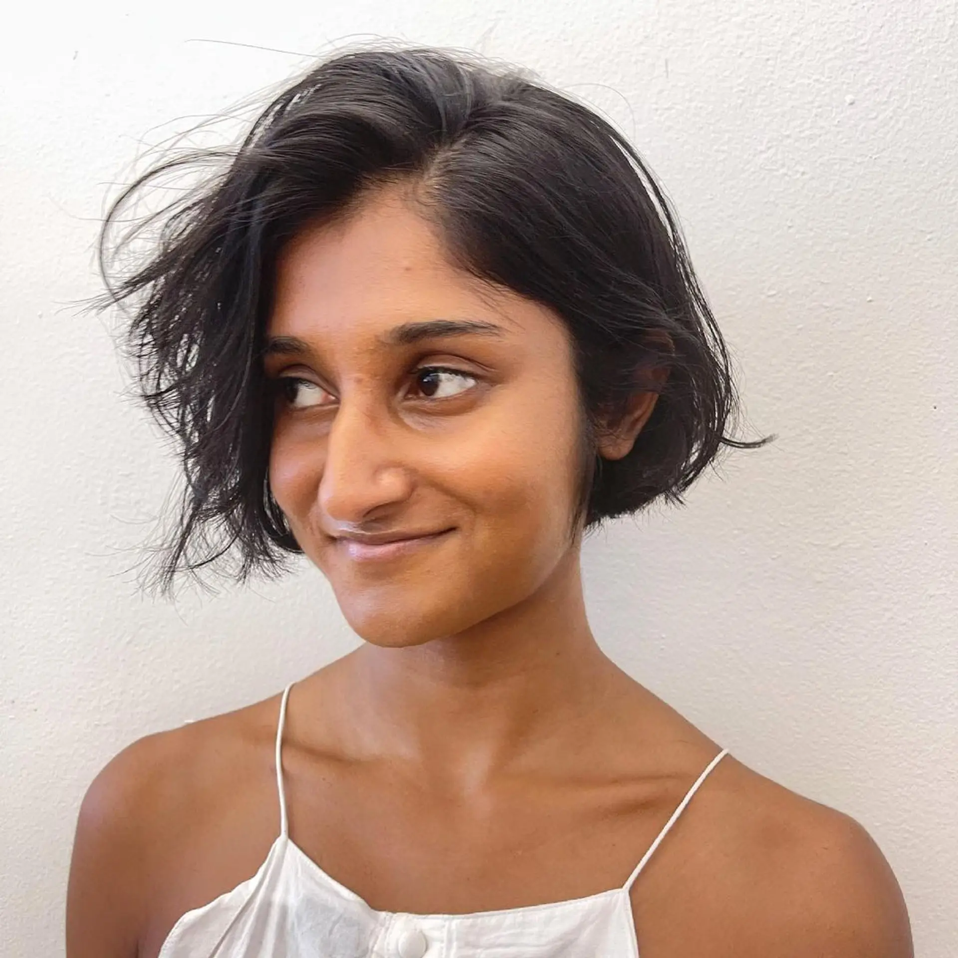 Short, chic tousled bixie cut (Pixie + Bob) with a natural wave and textured ends, creating a casual and effortless look. 3