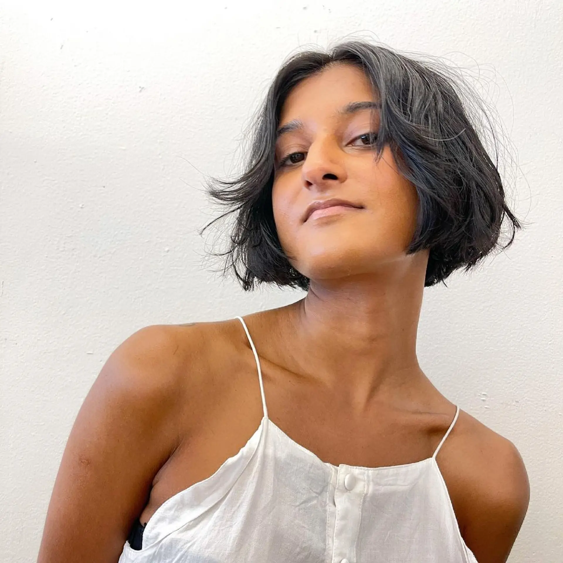 Short, chic tousled bixie cut (Pixie + Bob) with a natural wave and textured ends, creating a casual and effortless look. 1