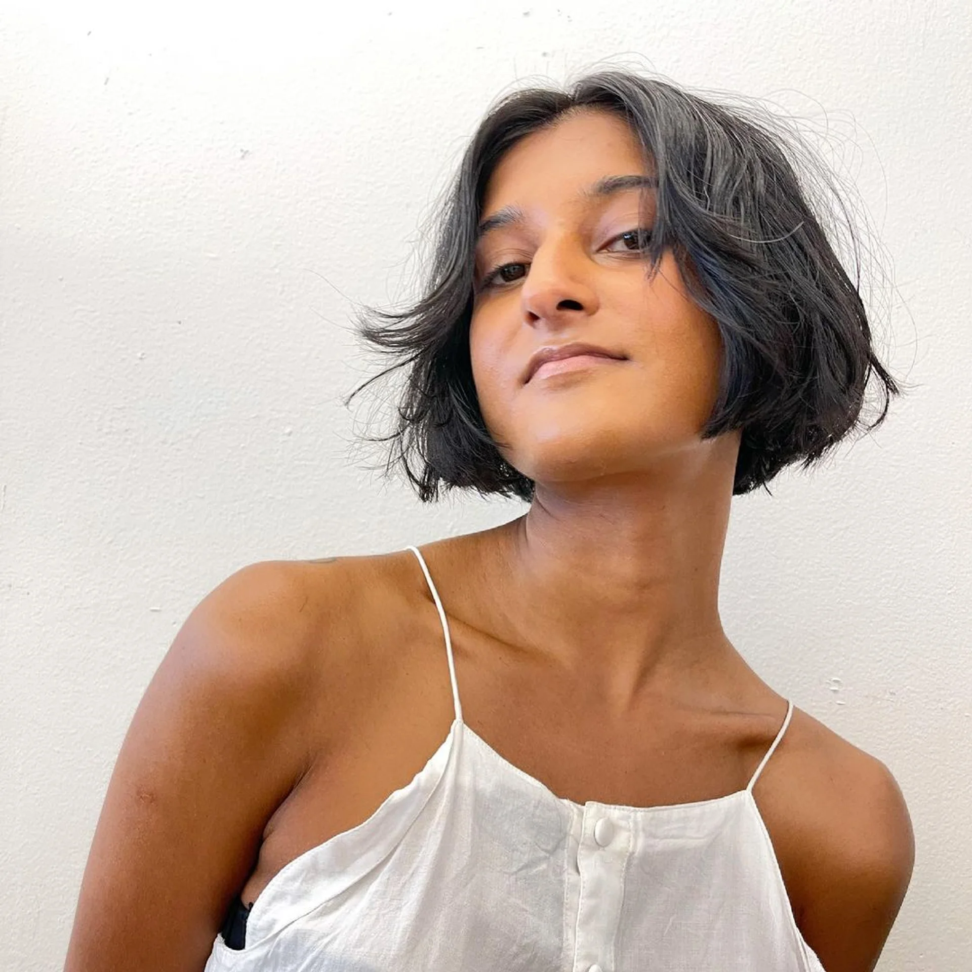 Sleek box bob with blunt bangs and vibrant money piece highlights, showcasing a precise jawline cut - Preview 1