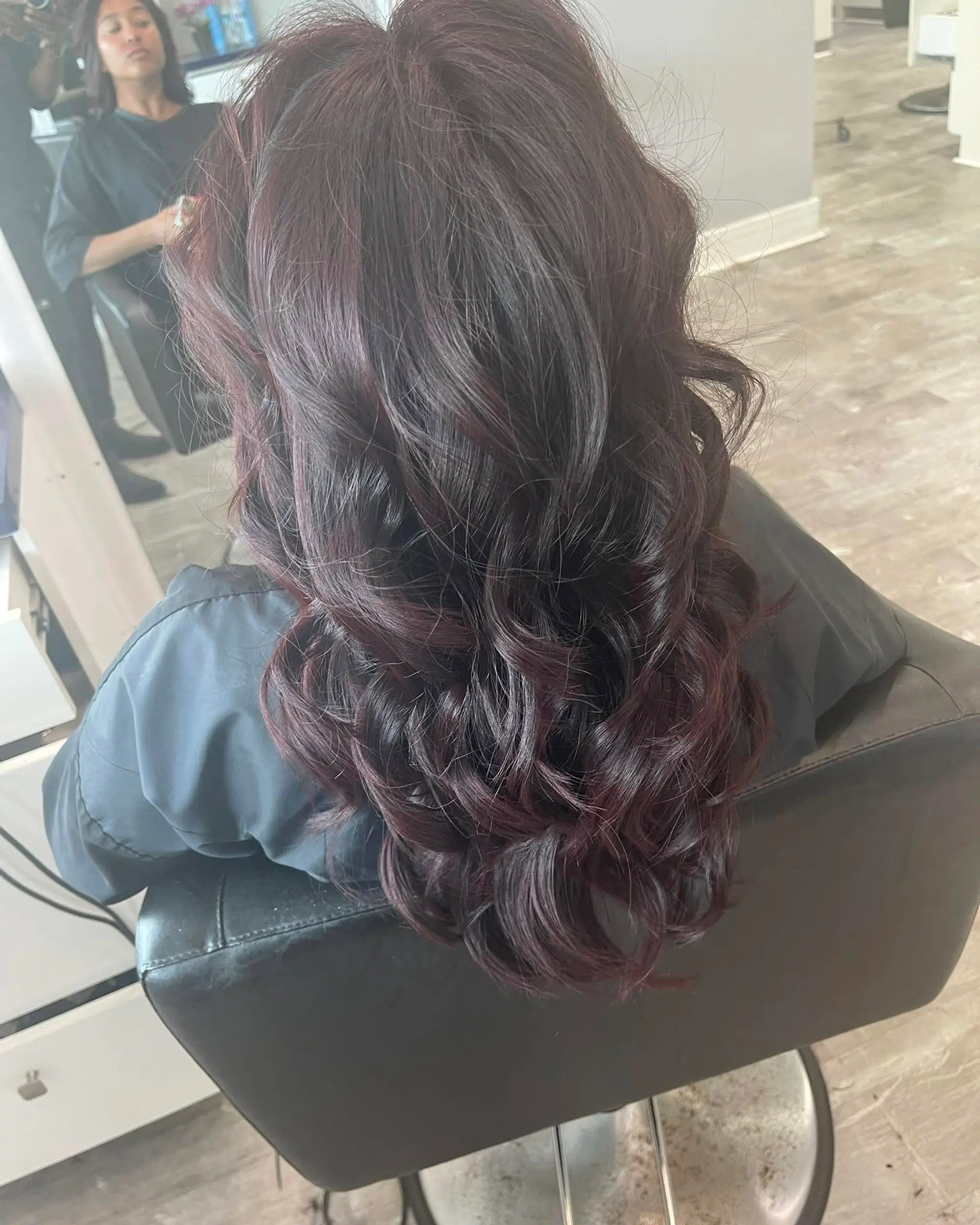 A long, wavy hairstyle featuring a rich burgundy color with romantic waves. 1