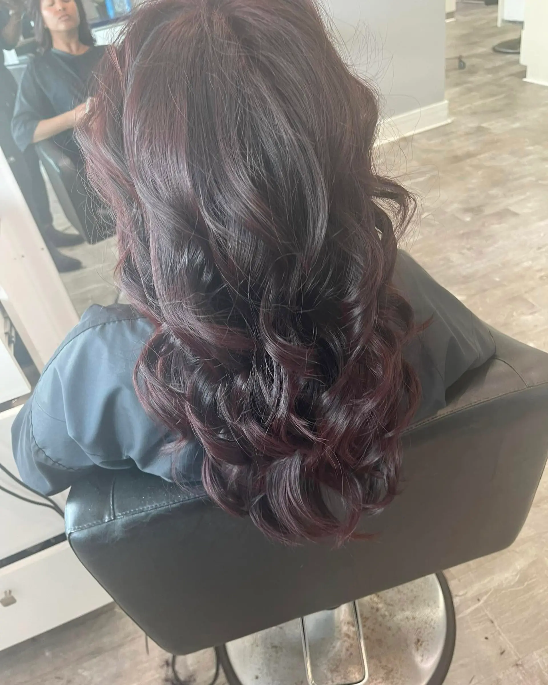 A long, wavy hairstyle featuring a rich burgundy color with romantic waves. 2